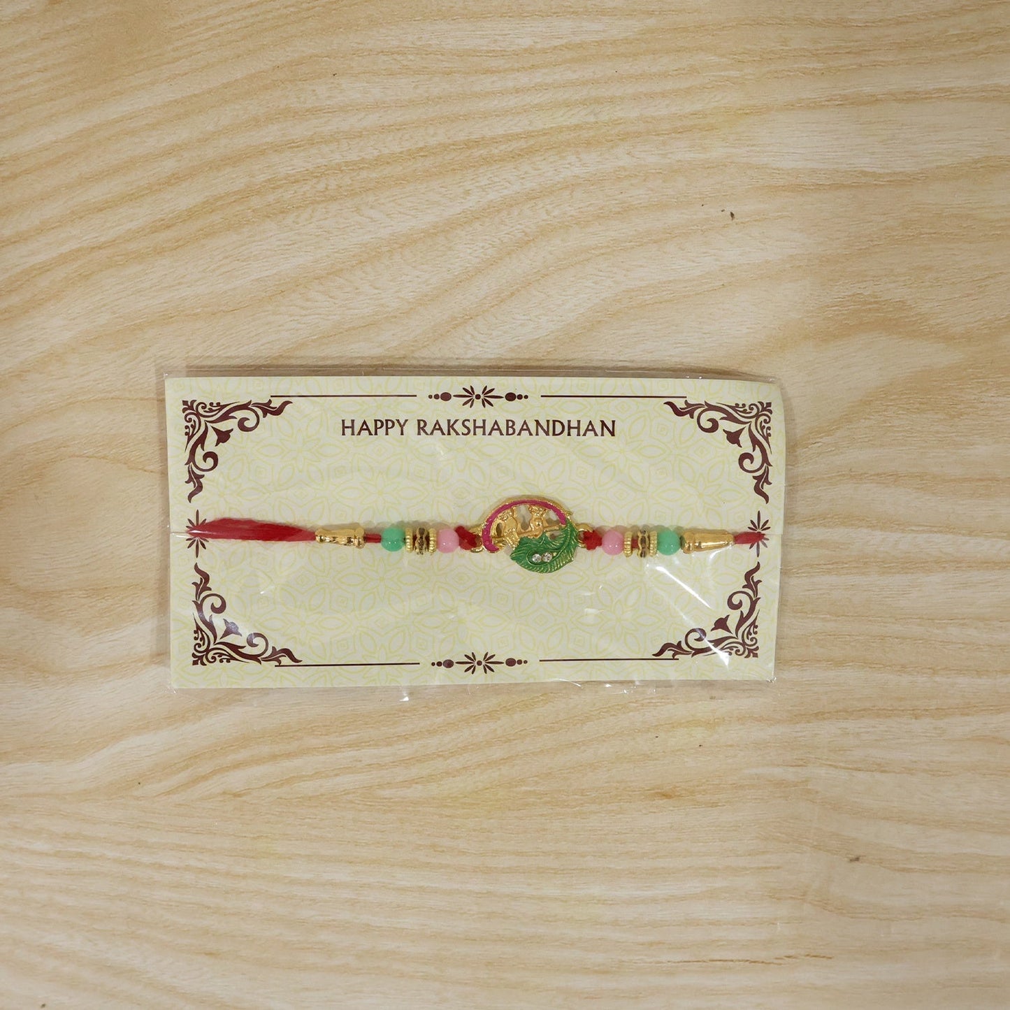 Packaging display of Mini Krishna Peacock Leaf Designer Rakhi