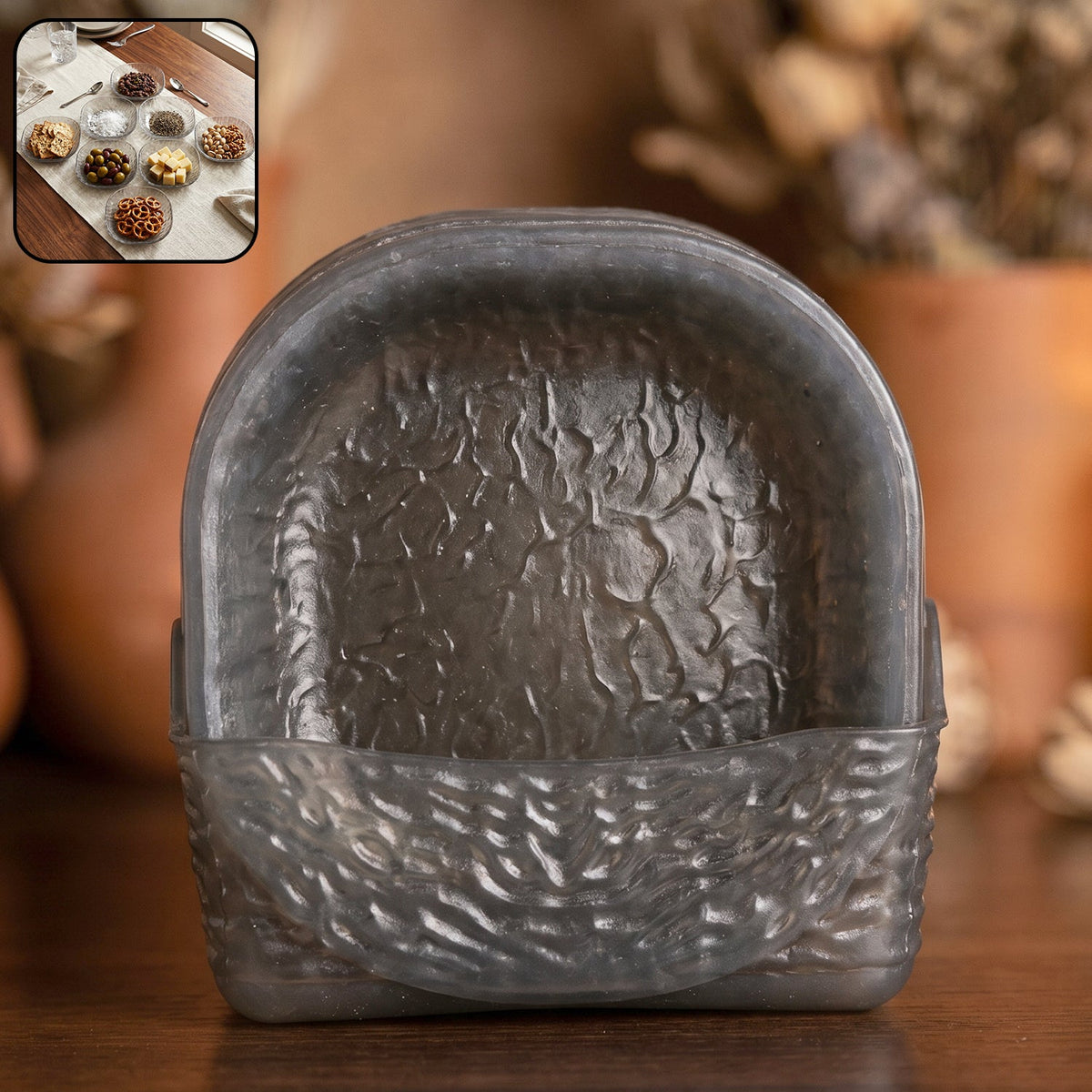 A dark gray textured glass storage basket holding several matching snack bowls, with a small inset showing a table setting.