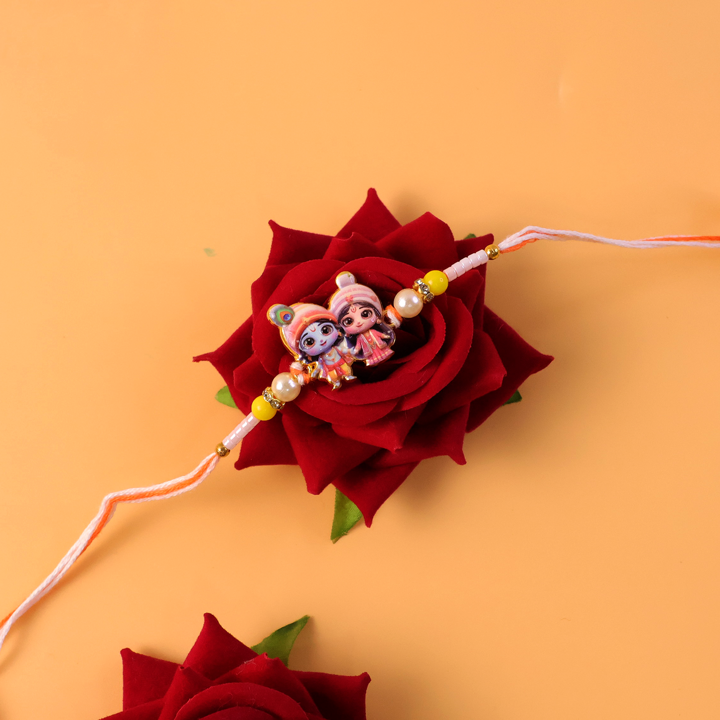 Top view of designer Lord Krishna Radha Rakhi with figurines.
