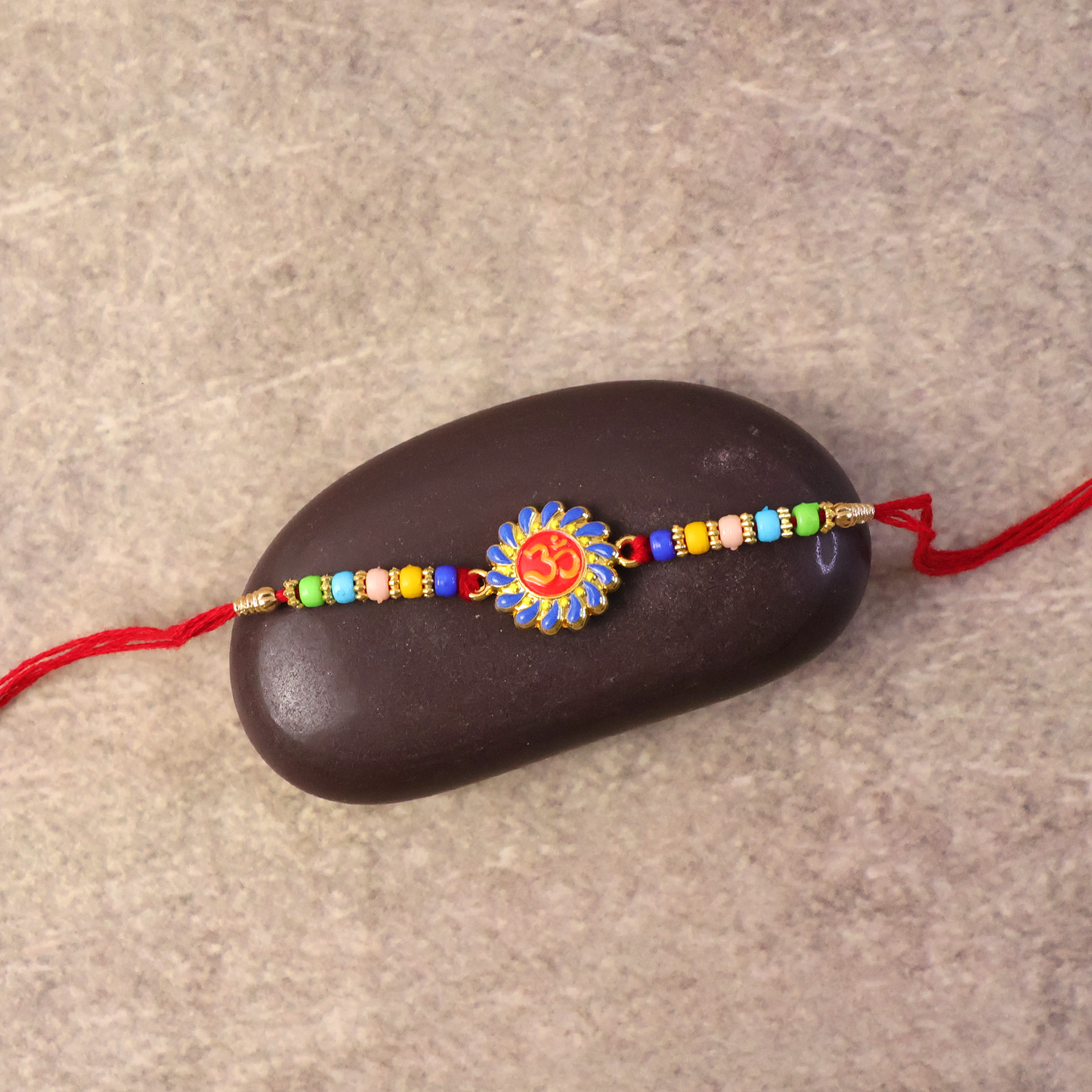 Om Rakhi styled with festive attire for Raksha Bandhan.