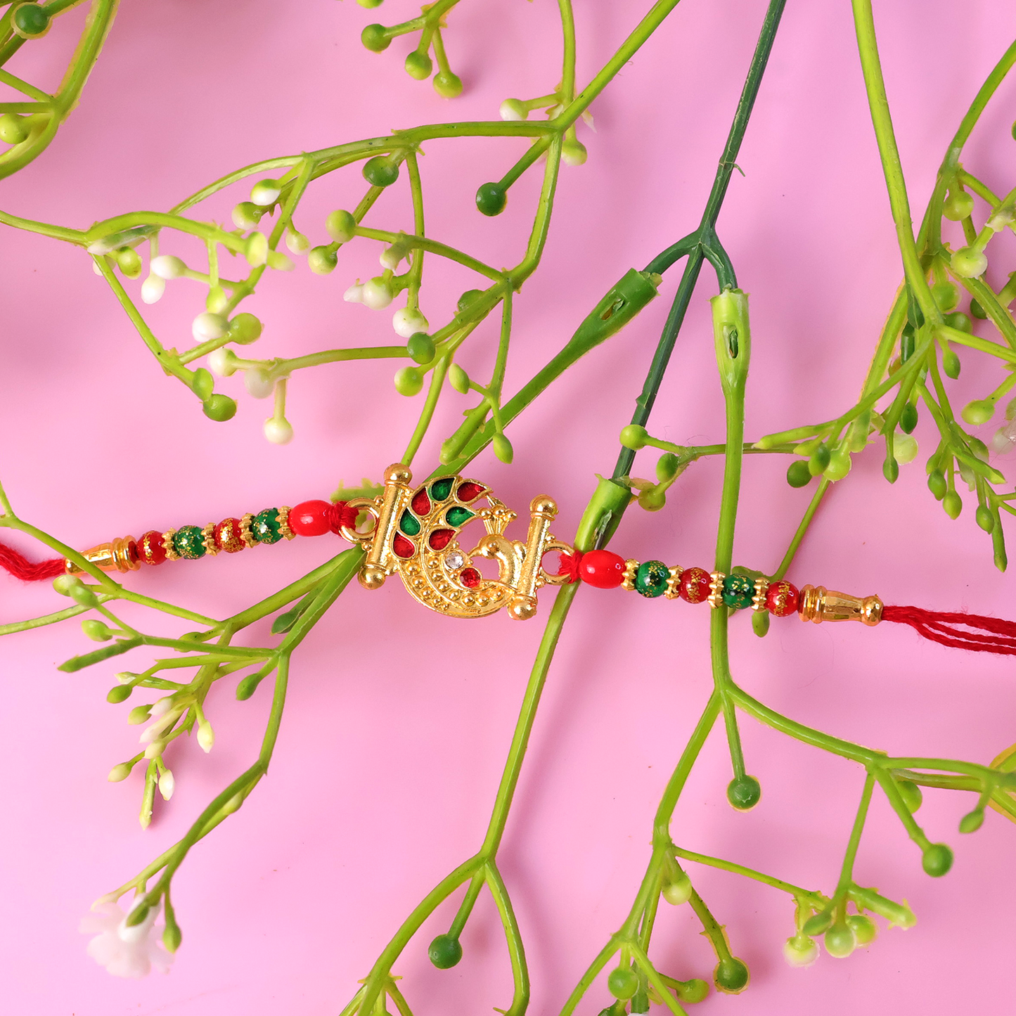 Decorative beads and thread work enhancing the Peacock Rakhi's beauty.