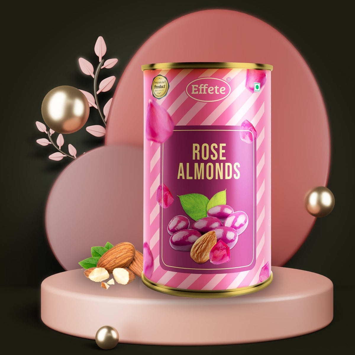 Pink and white striped tin of rose almonds on a pink pedestal, with loose almonds and decorative gold spheres on a dark