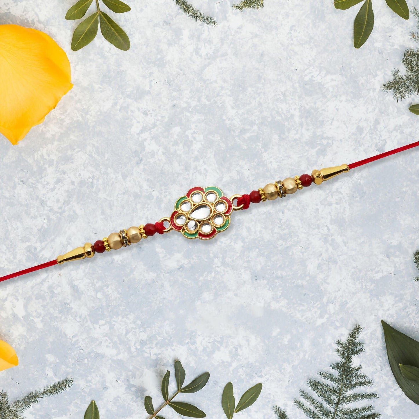 Kundan work floral rakhi tied with bright red thread, showcasing intricate craftsmanship