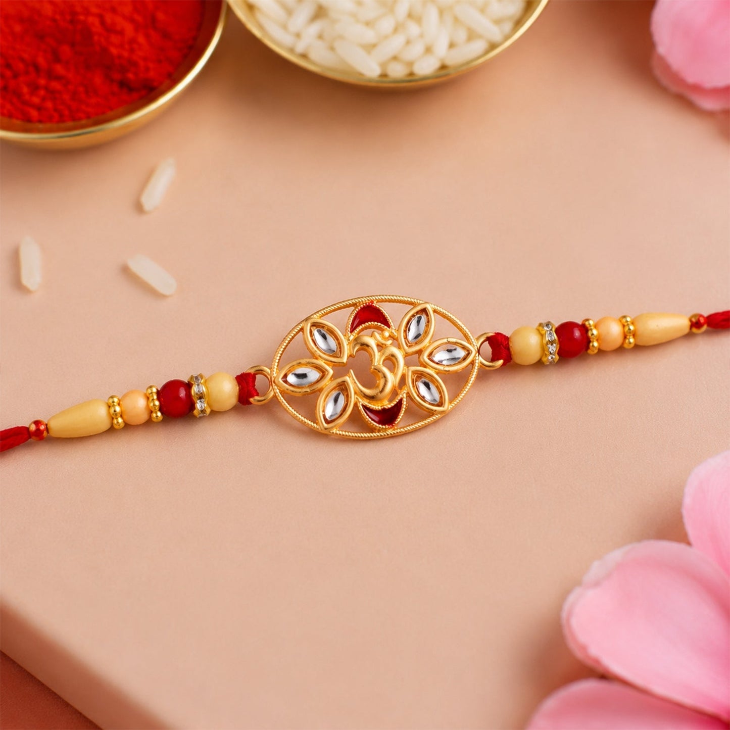 Om Kundan Rakhi with pearl beads on a vibrant red festive background for Raksha Bandhan.