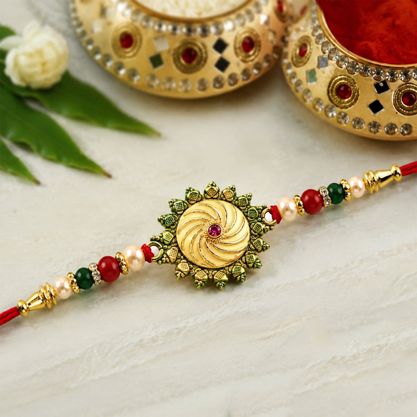 Round shape rakhi featuring intricate bead work with red and green accents