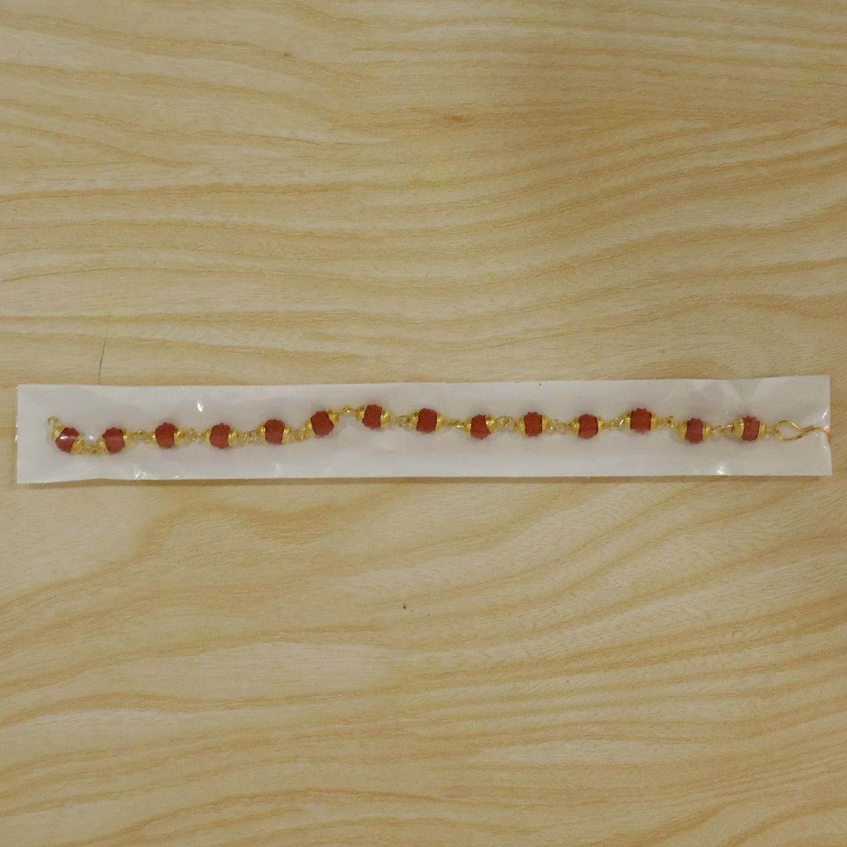 Rudraksha bead rakhi shown in a gift box packaging for Raksha Bandhan.
