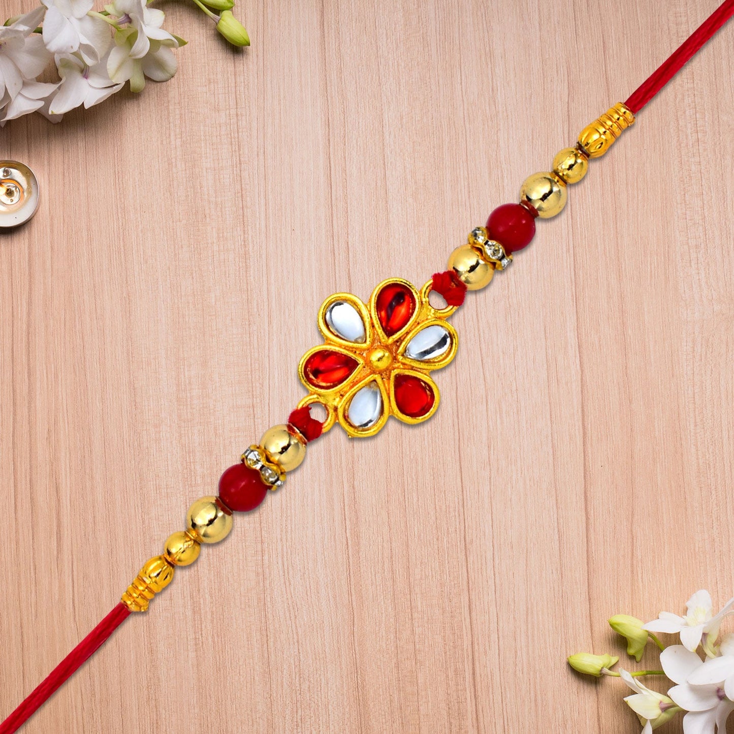 Red and white beaded Rakhi with teardrop Kundan floral centerpiece on display