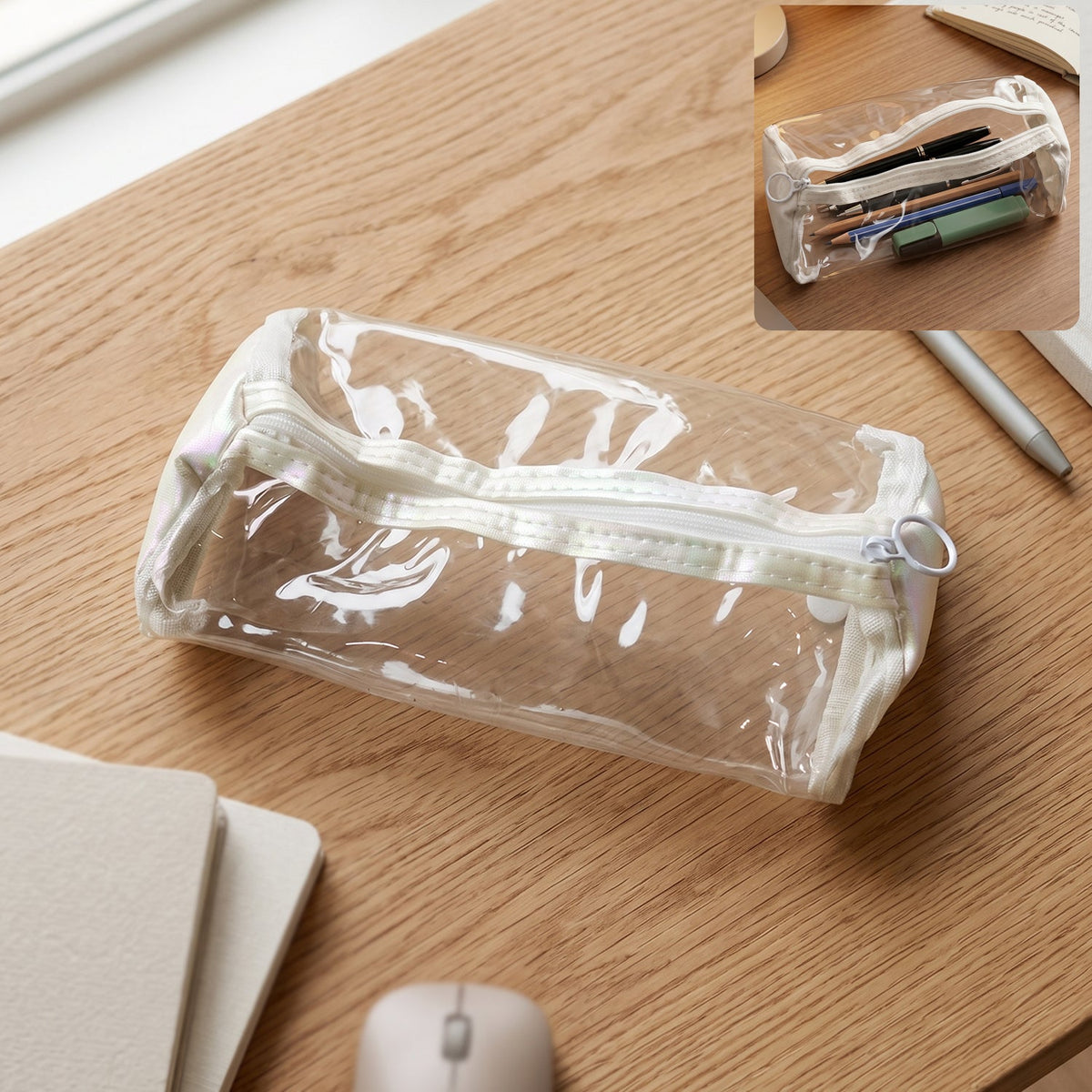 Clear PVC pencil case with white trim and zipper on a wooden desk with a small inset image of the case.