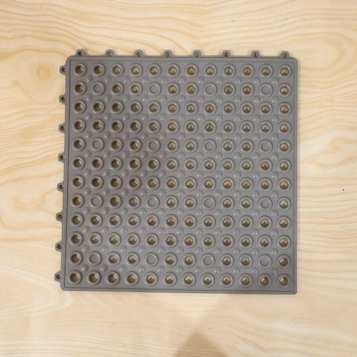 Close-up of textured surface and drainage holes in bathroom anti slip mat
