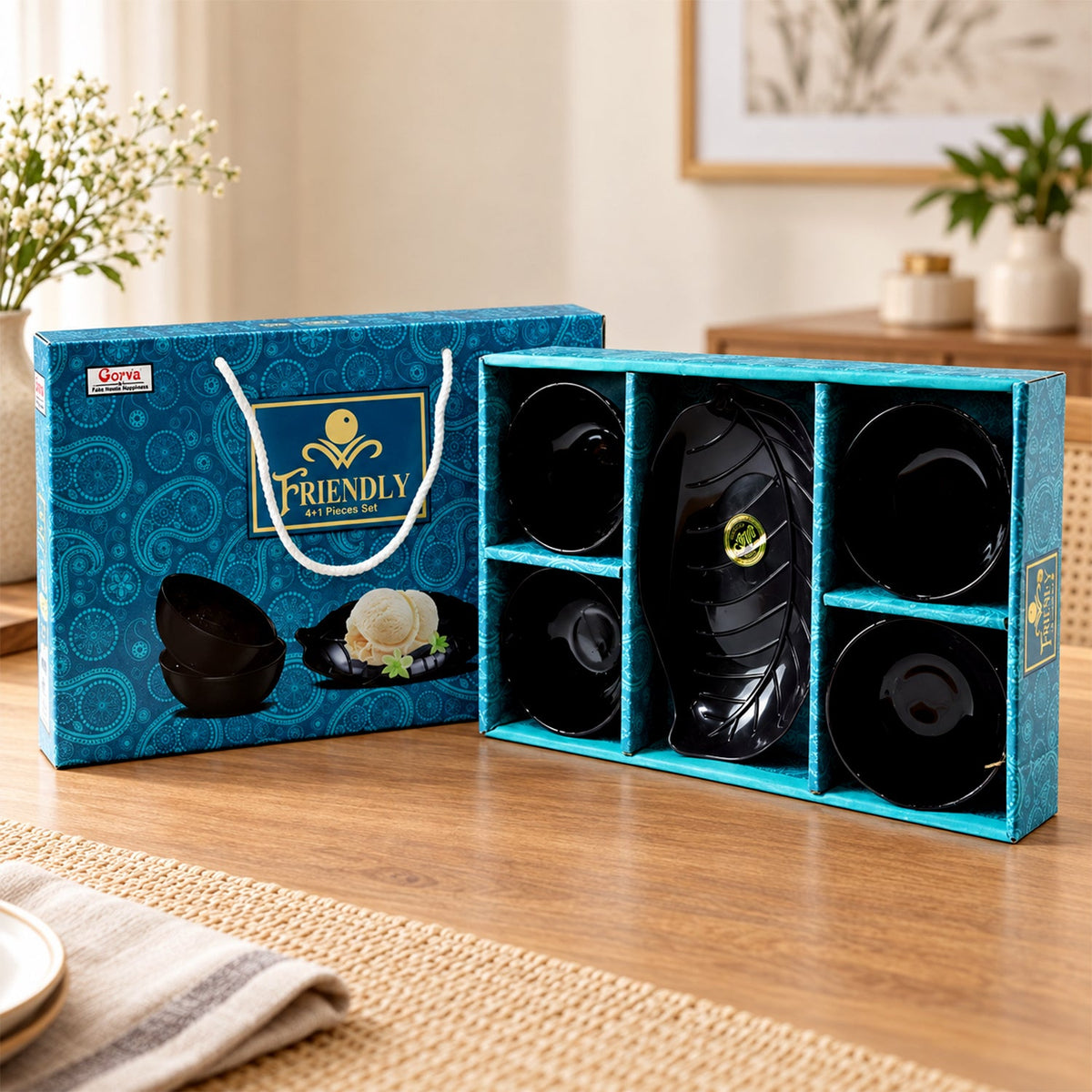 A black leaf-shaped platter and four small black bowls are displayed in a blue patterned gift box.