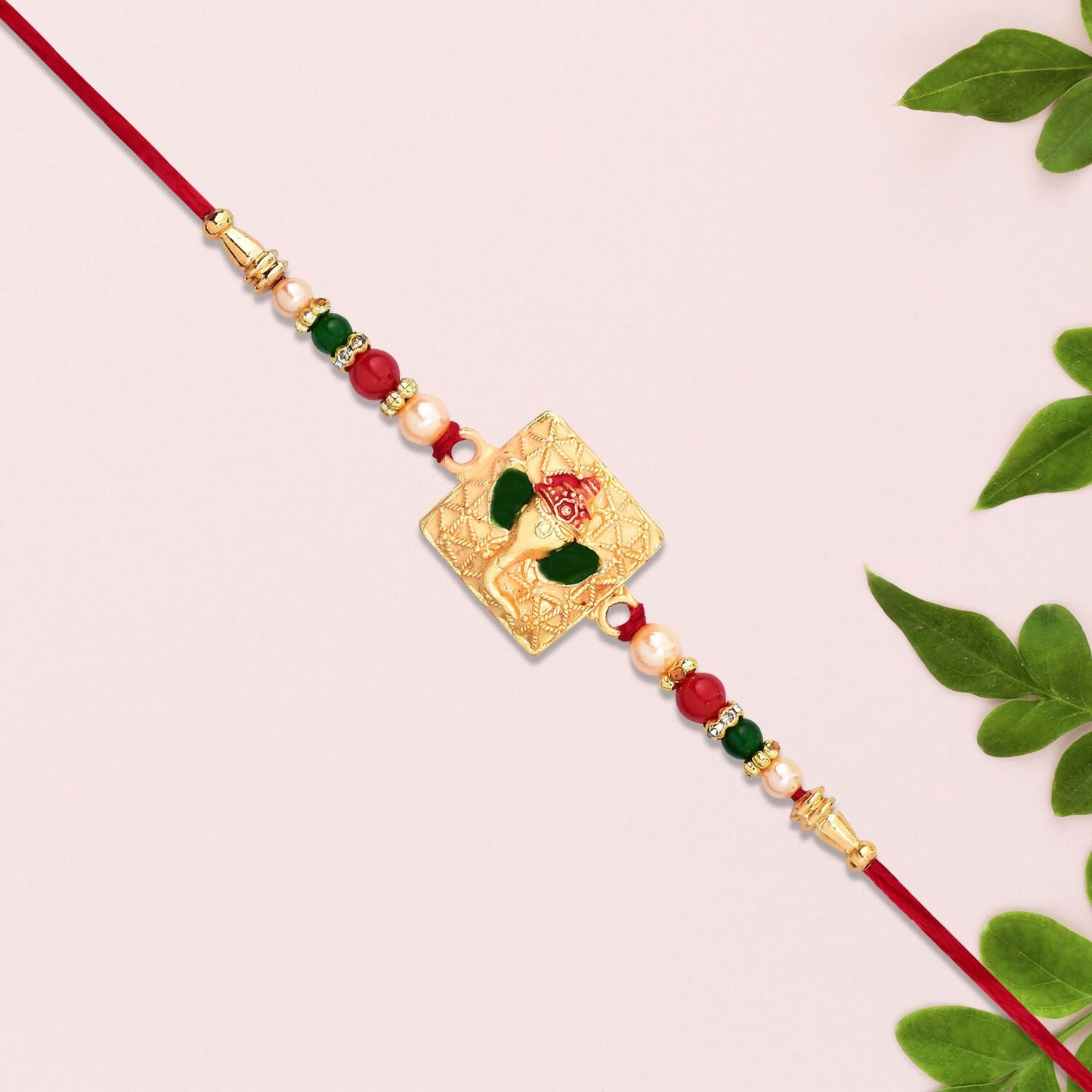 Close-up of Golden Ganpati Rakhi highlighting intricate enamel detailing