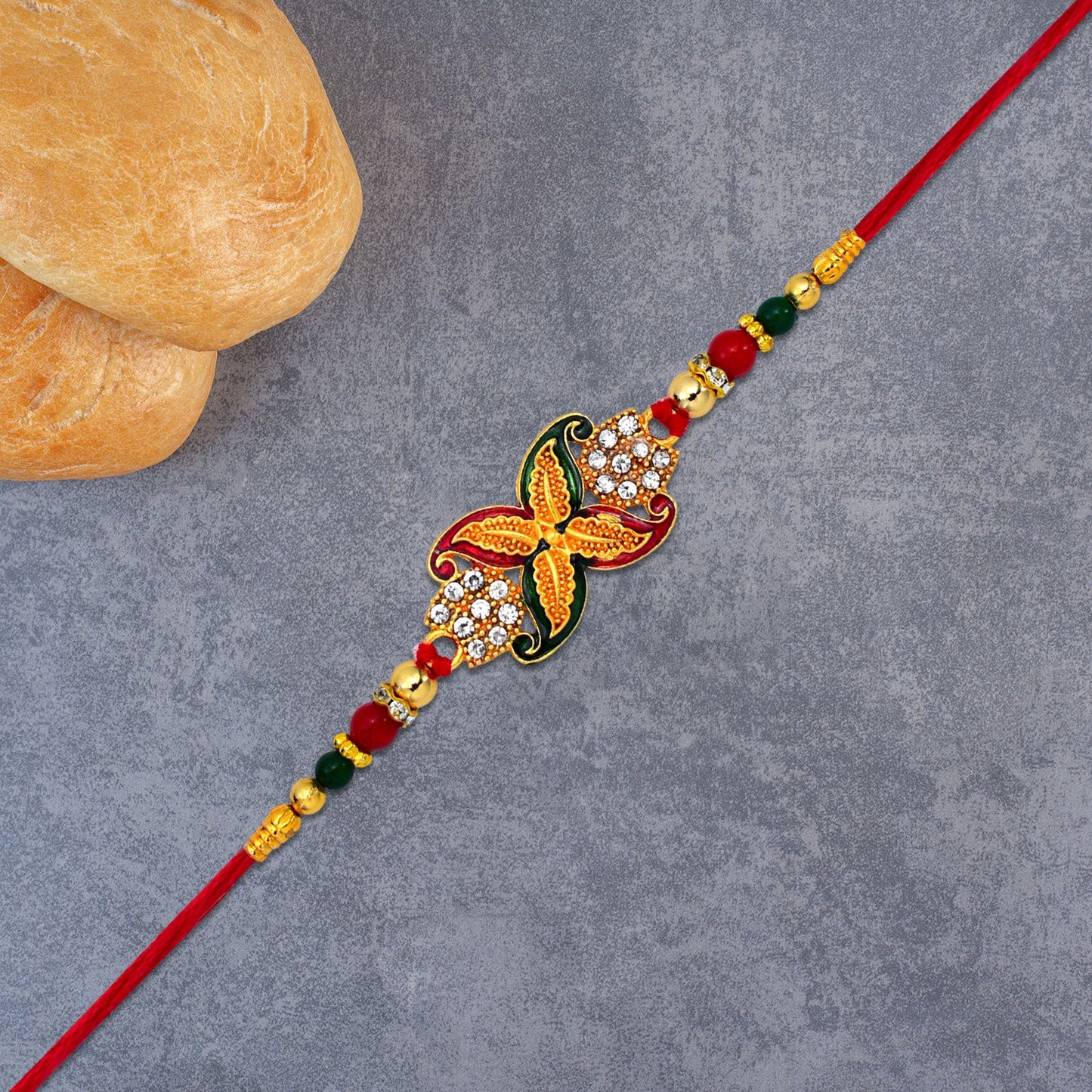 Close-up of bead Rakhi showcasing intricate golden flower motif design