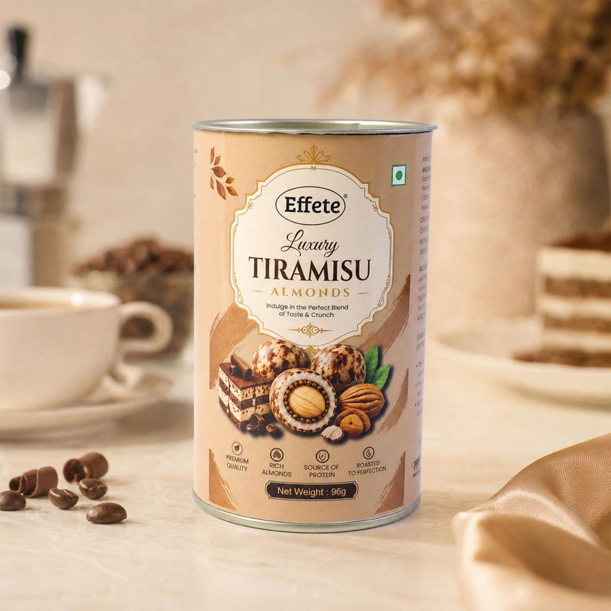 A tall, cylindrical tin of Effete Luxury Tiramisu Almonds sits on a white counter with coffee items.