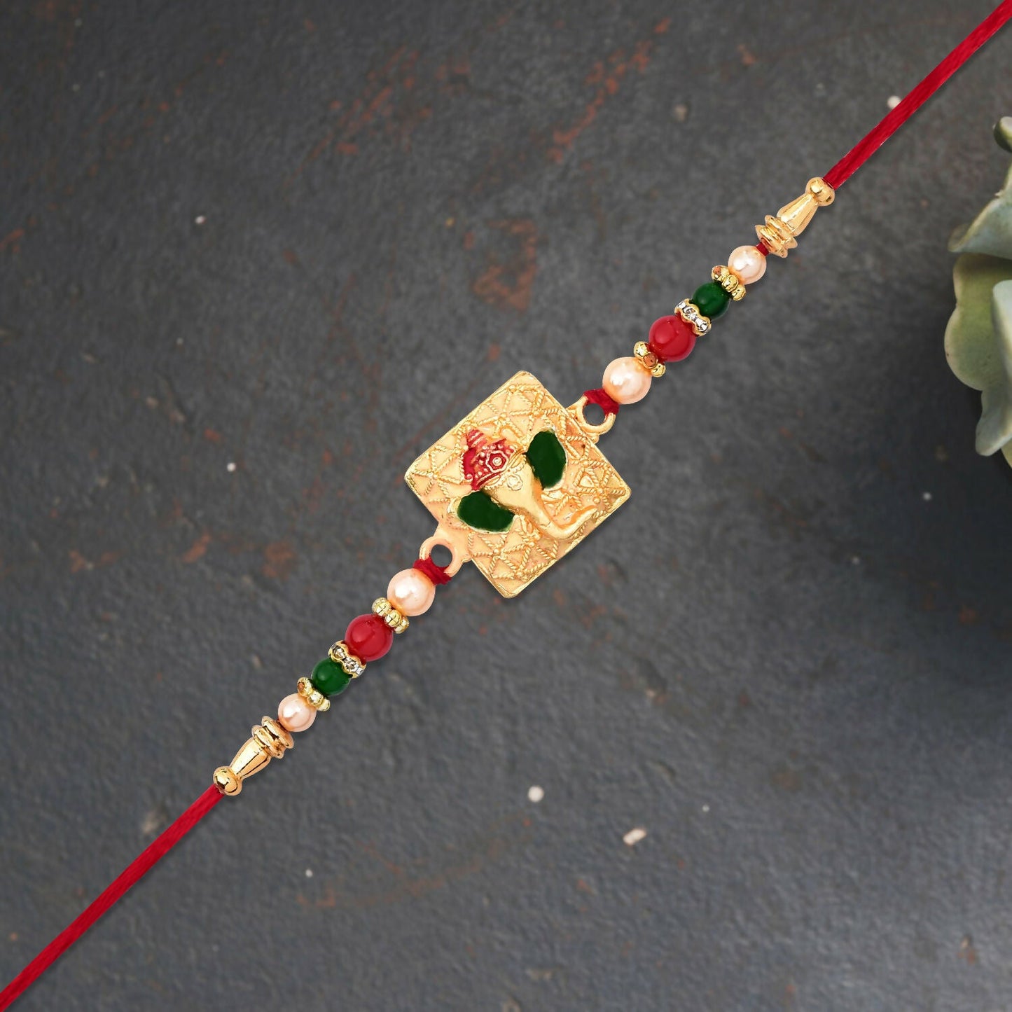 Golden Ganpati Rakhi with colorful bead accents and enamel finish for Raksha Bandhan
