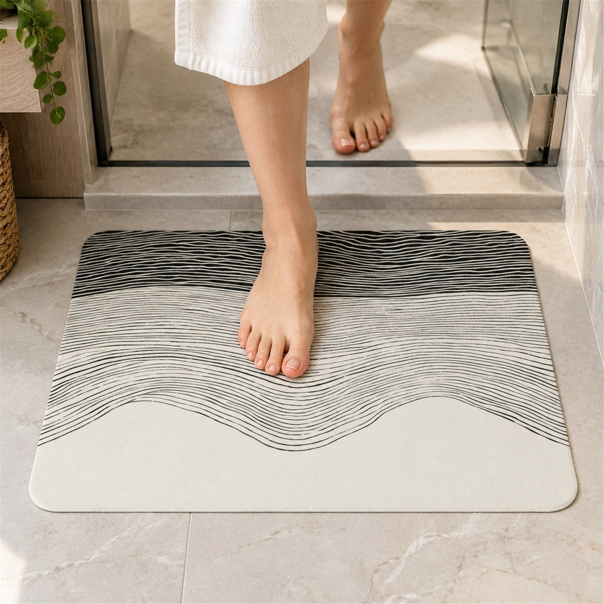 A person steps out of a shower onto a rectangular mat with a black and white wavy line design.