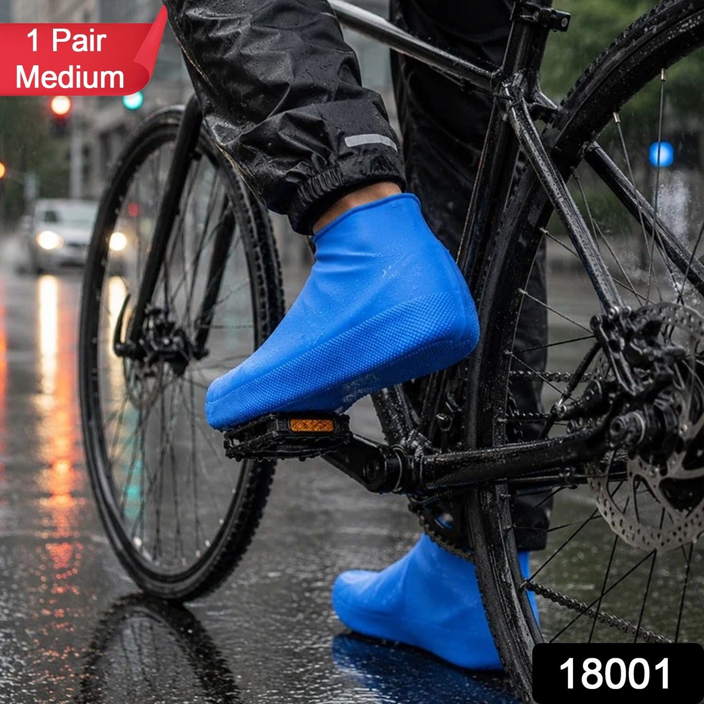 A person on a bicycle wears blue waterproof shoe covers on a wet city street, with a red "1 Pair Medium" label.