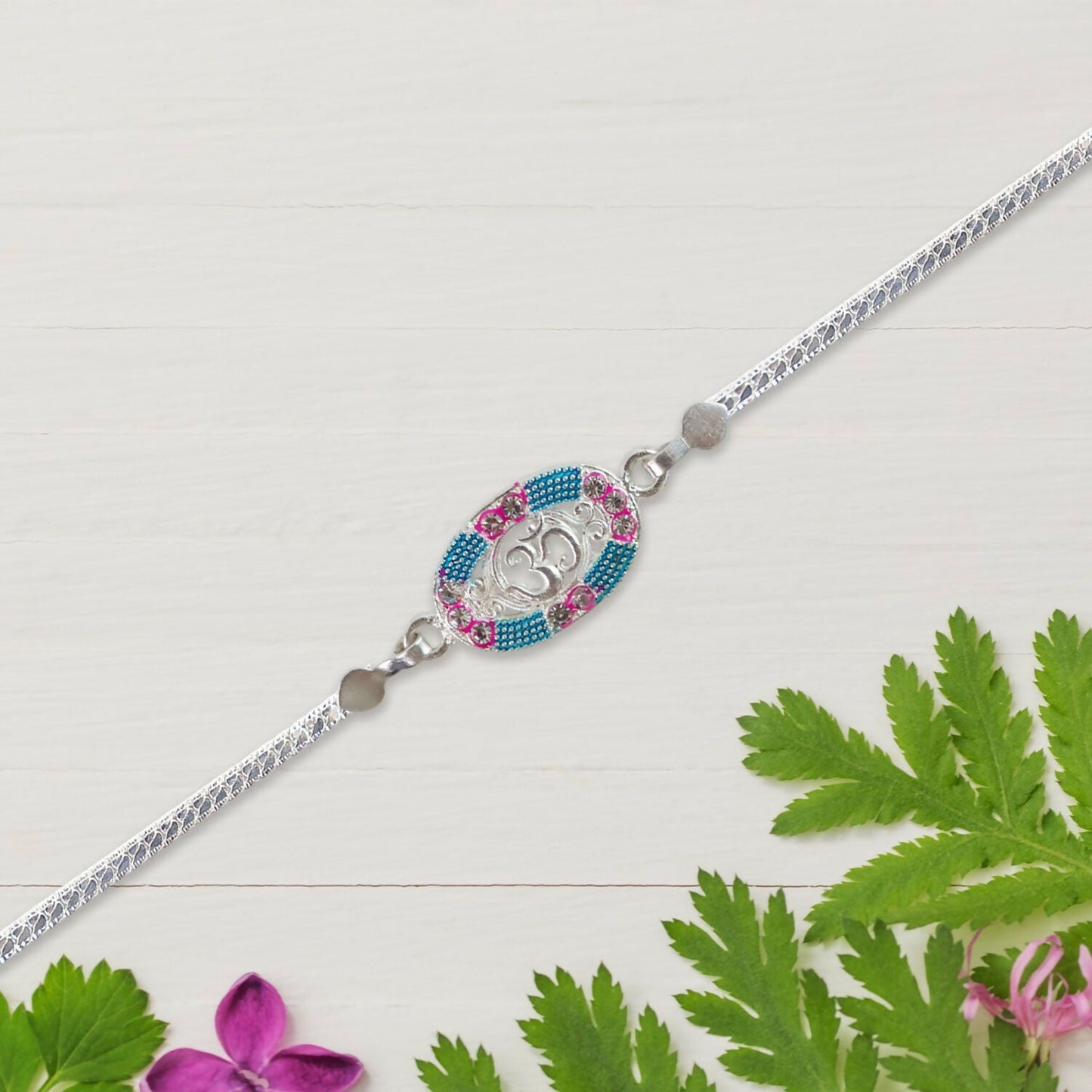 Silver rakhi tied with red thread symbolizing protection and brotherly love