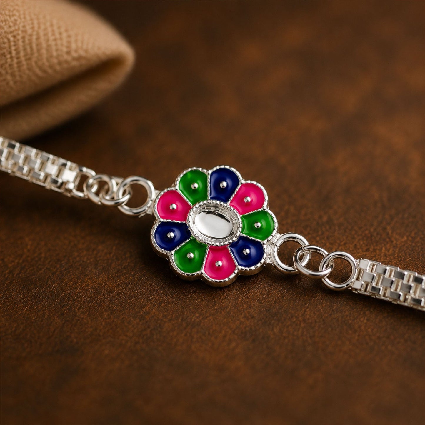 Close-up of the delicate floral pattern and colorful enamel detailing on the Rakhi.