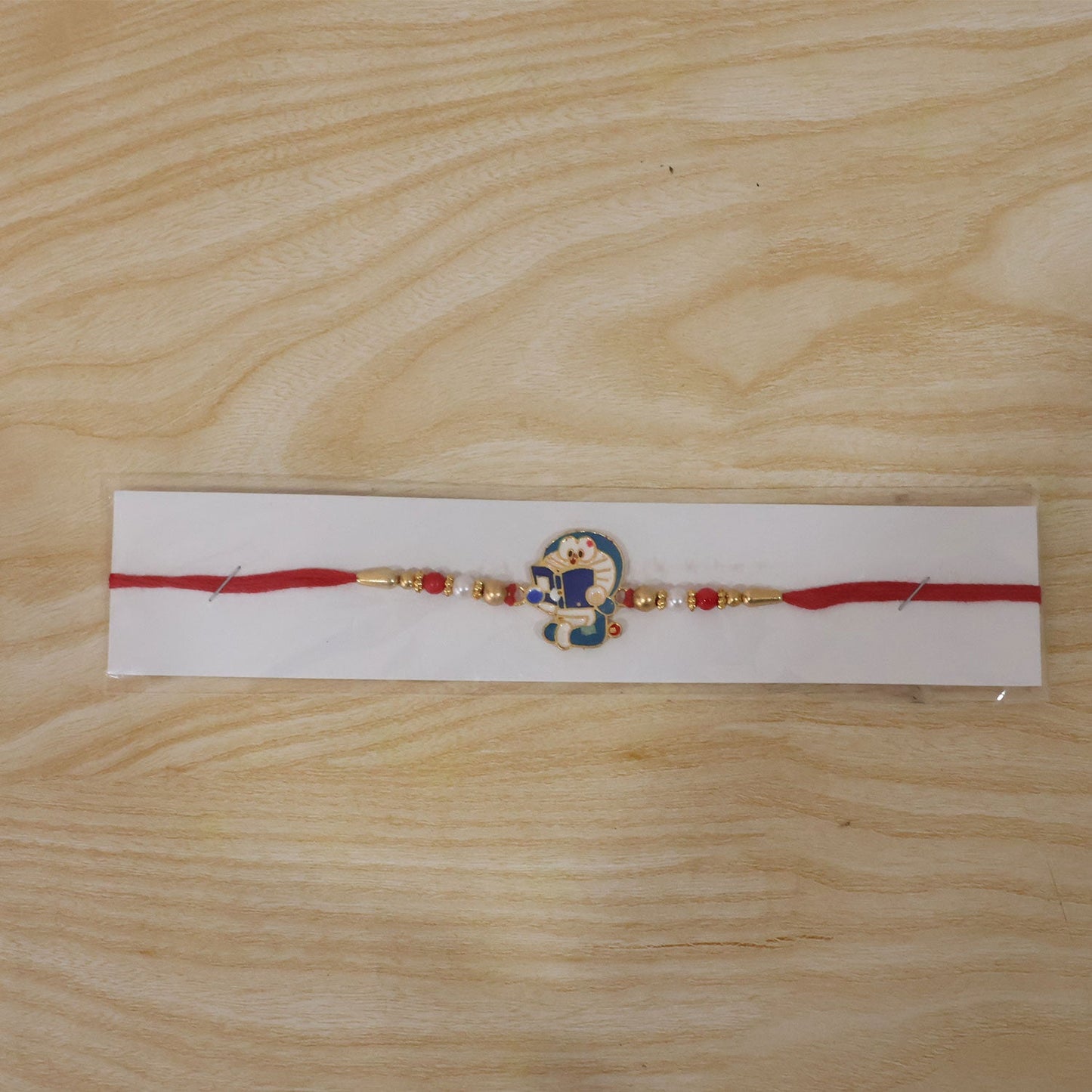 Festive Doraemon Kids Rakhi with vibrant beads and fun charm.