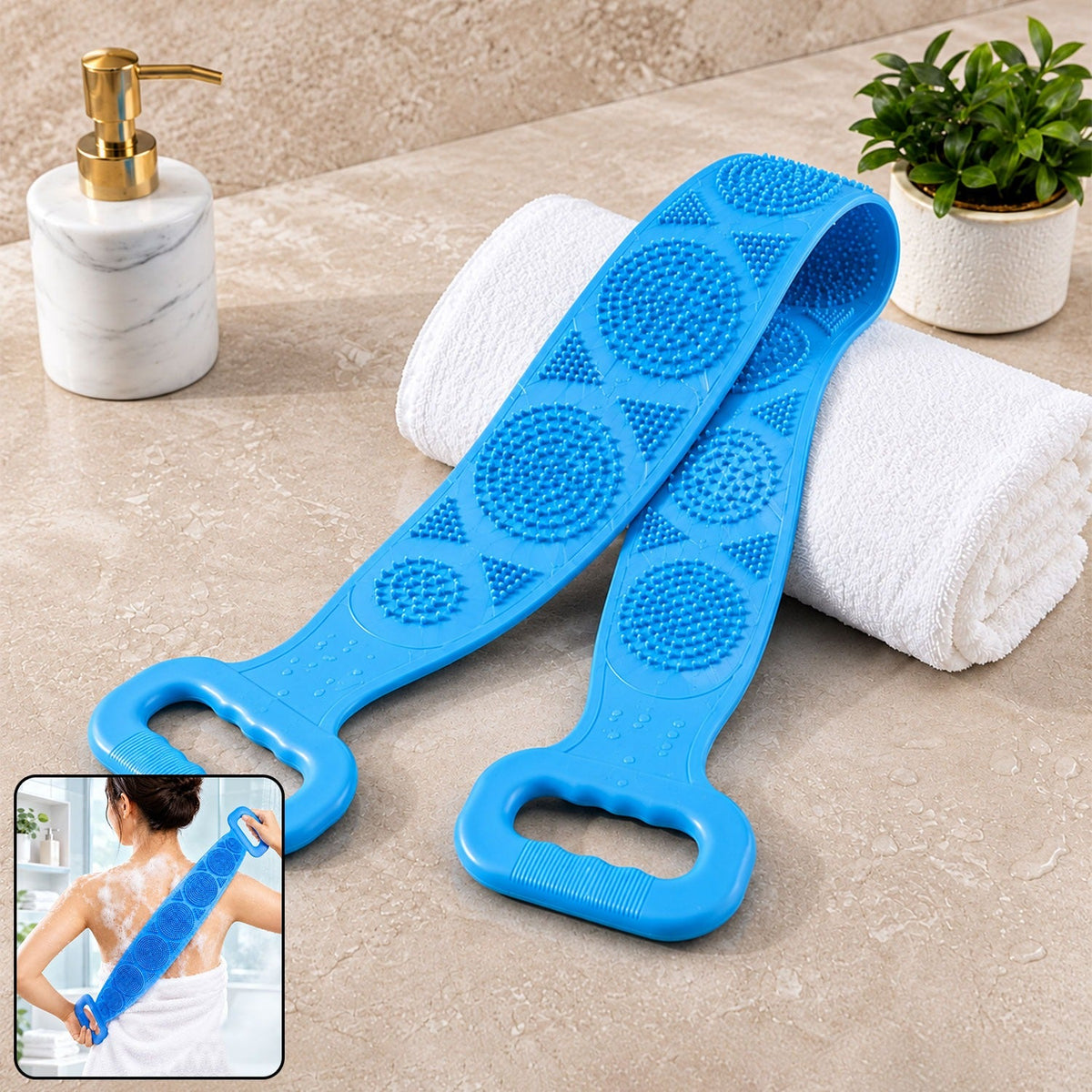 A blue silicone back scrubber with textured surfaces and handles rests on a white towel next to a soap dispenser.