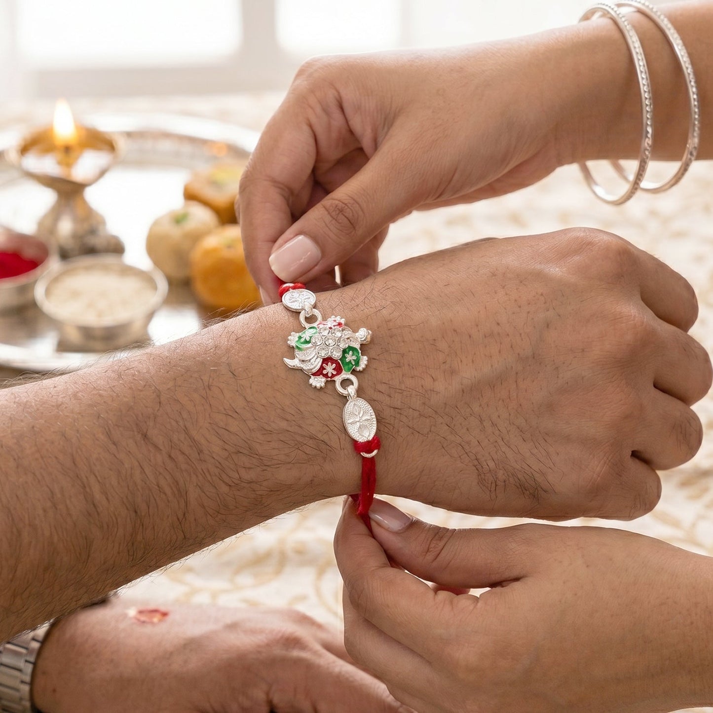 Angled view of the Turtle Rakhi with crystal embellishments.