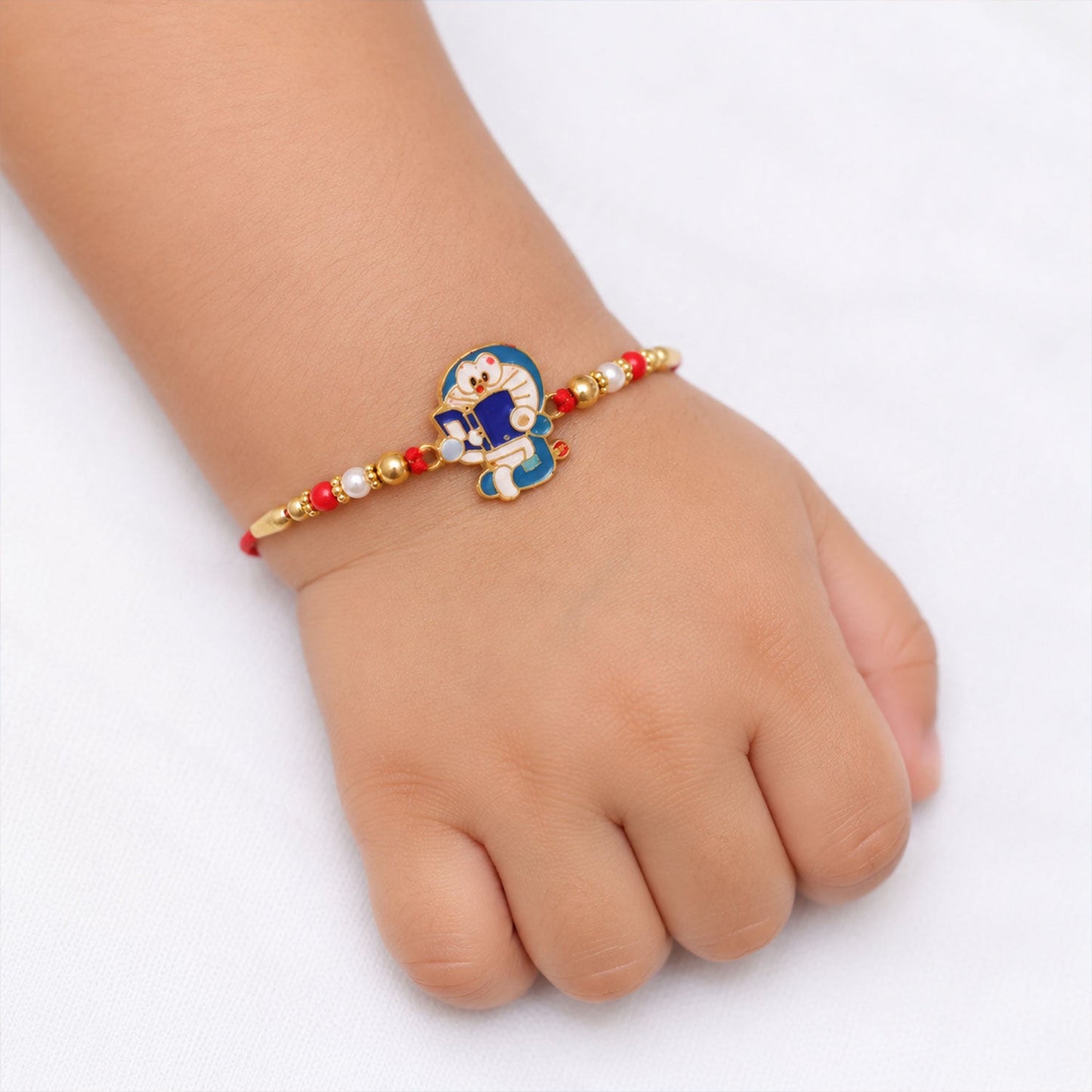Wrist view showing the vibrant blue charm and beads of the Rakhi.