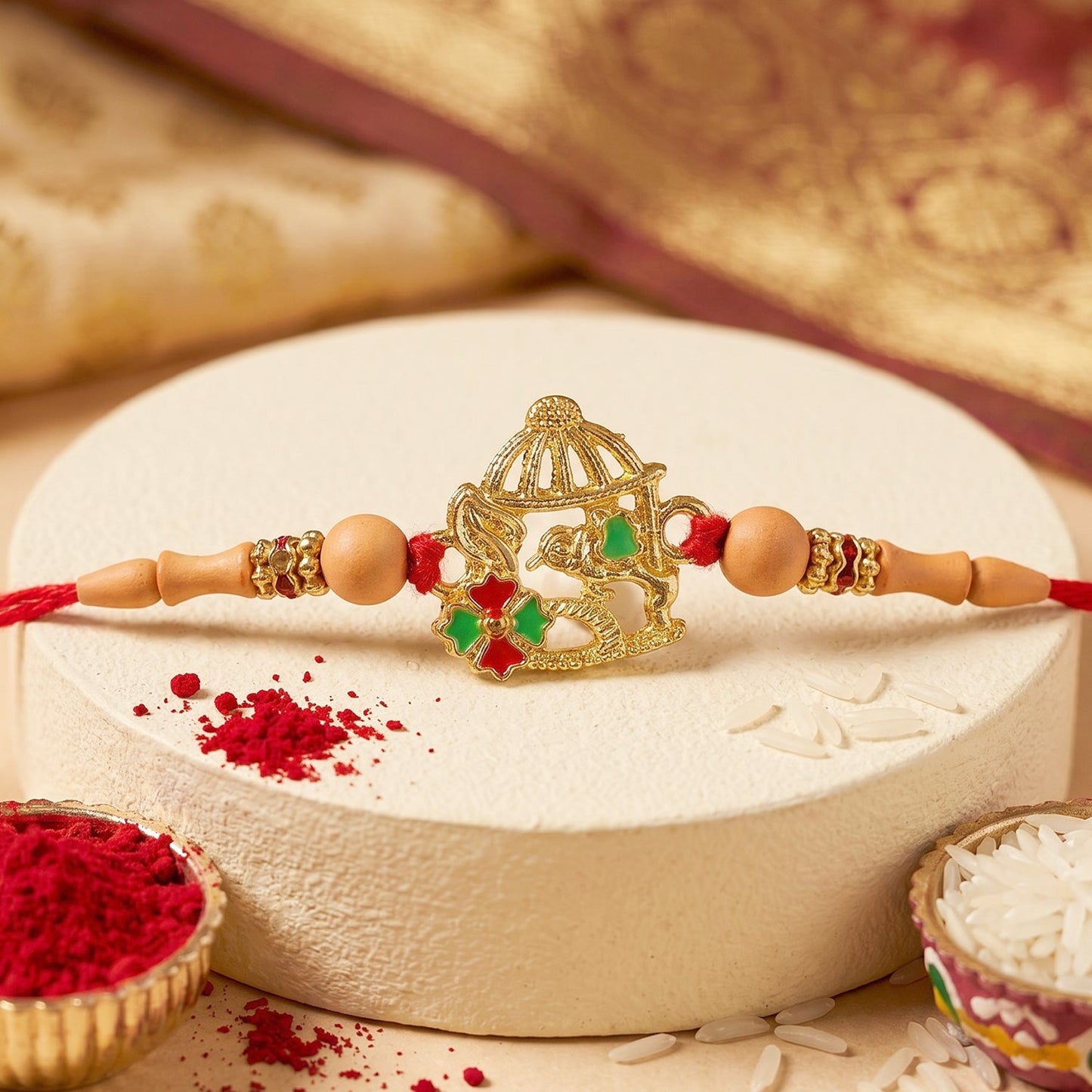 Close-up of golden bow and arrow Rakhi detail with beads