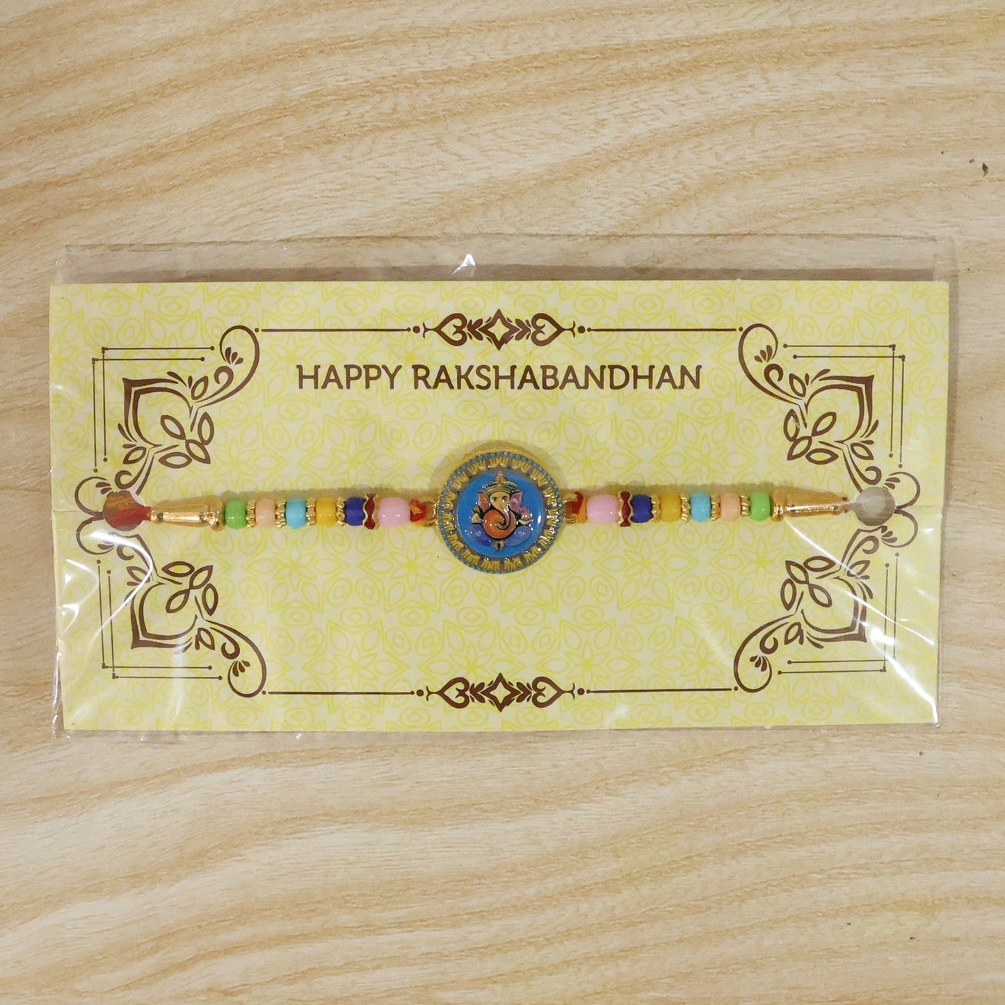 Elegant designer Rakhi with coin centerpiece and embellishments