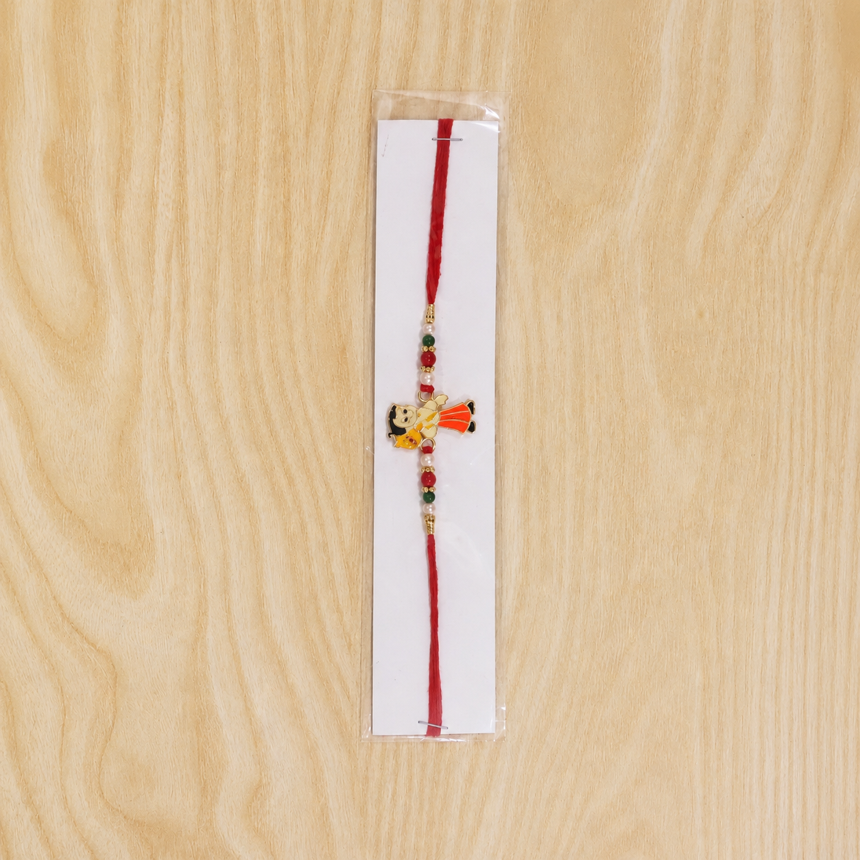 Overhead shot of green and red bead Kids Cartoon Rakhi for celebrations.
