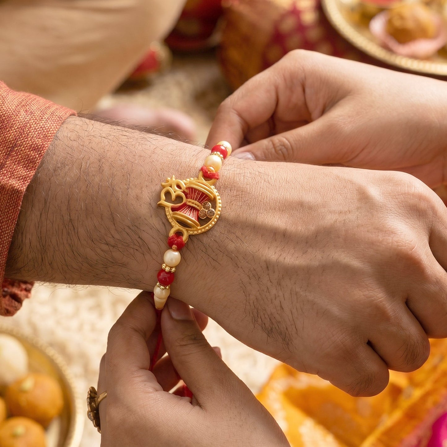Close-up of the golden Om symbol on the Damru Rakhi, perfect for brothers.