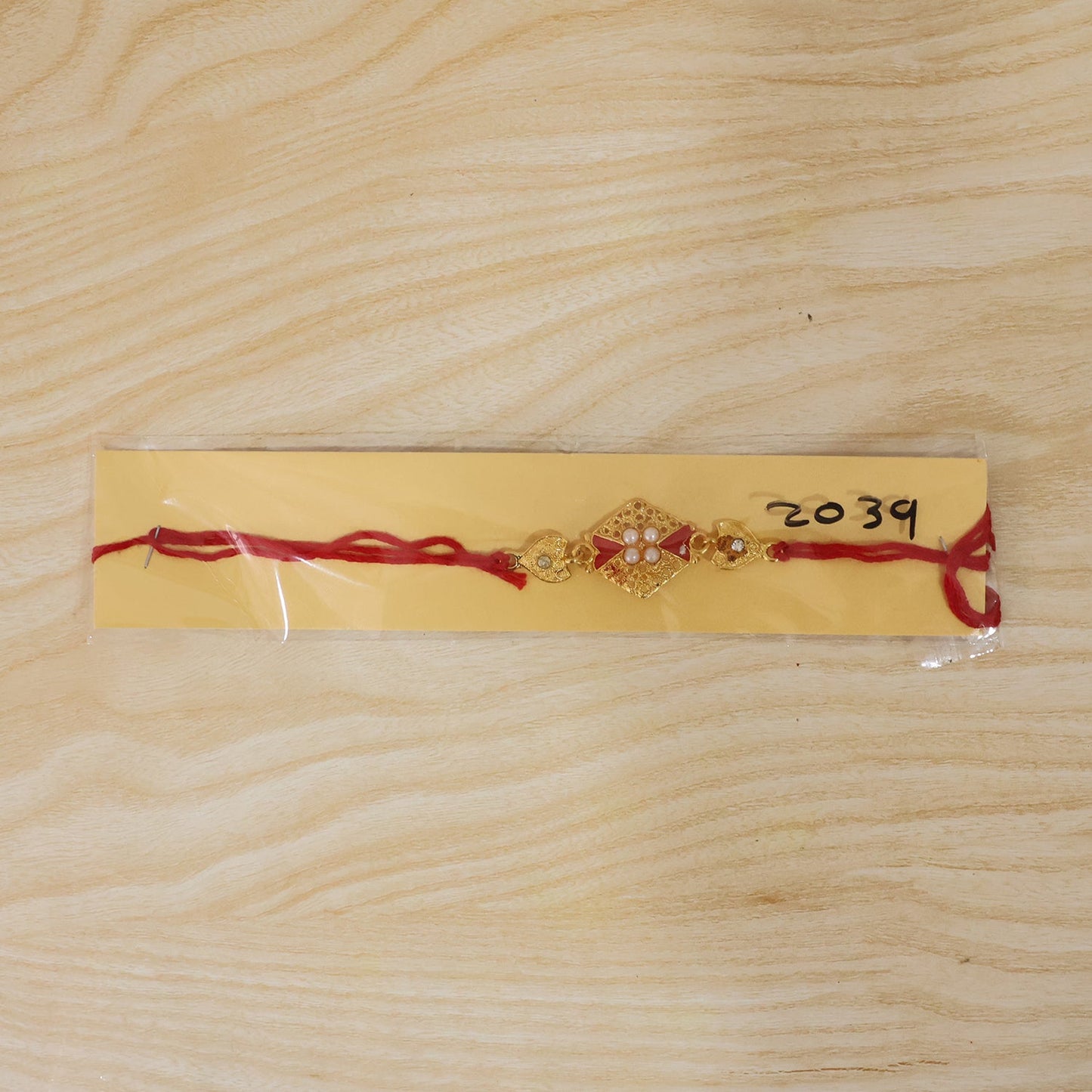 Festive design of Red Kundan Rakhi with pearls and gold accents