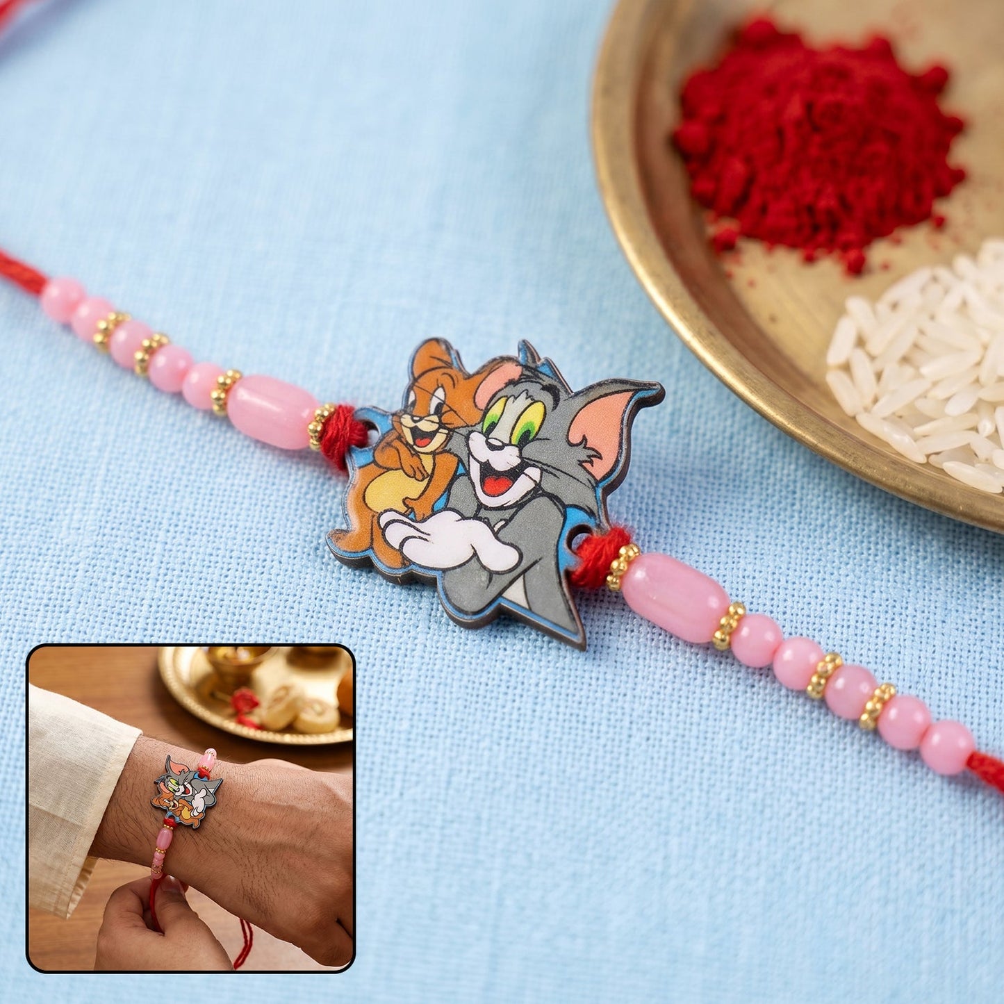Cartoon kids rakhi with pink beads and gold accents on thread
