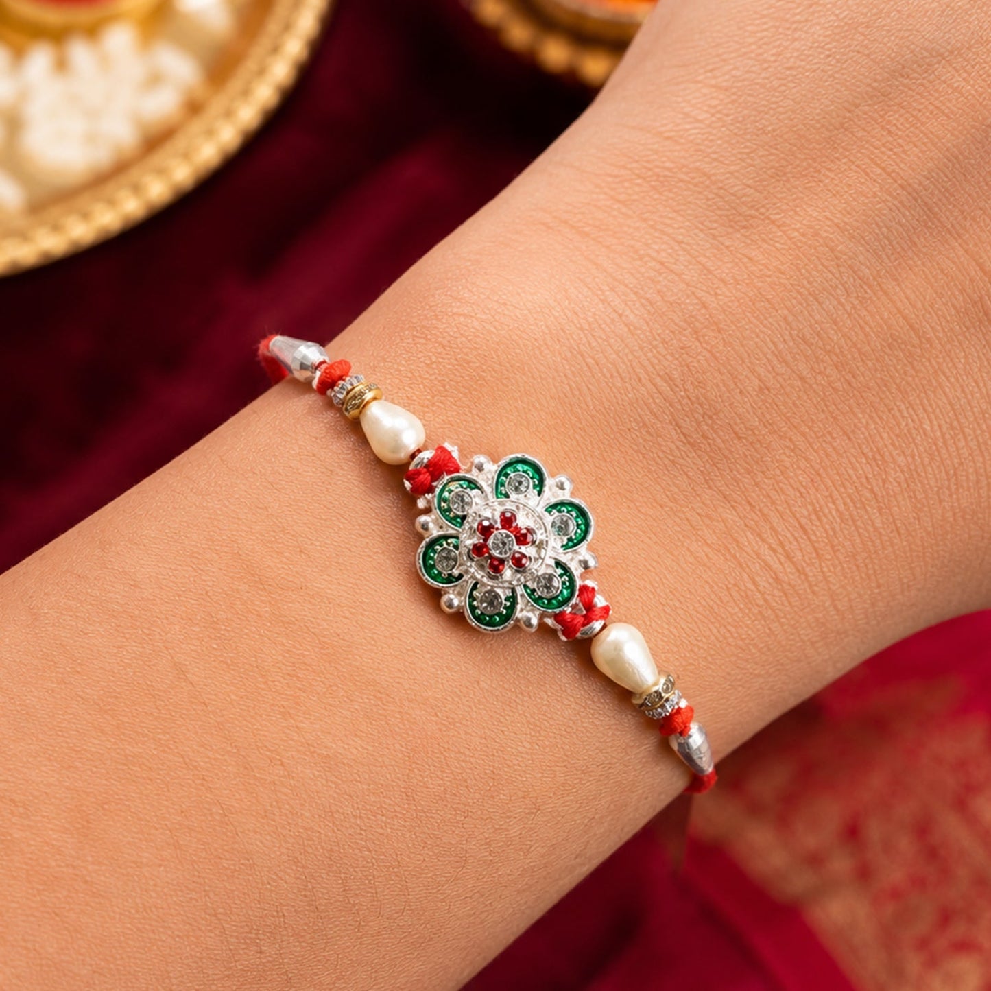 Close-up of green flower rakhi with intricate red beads design