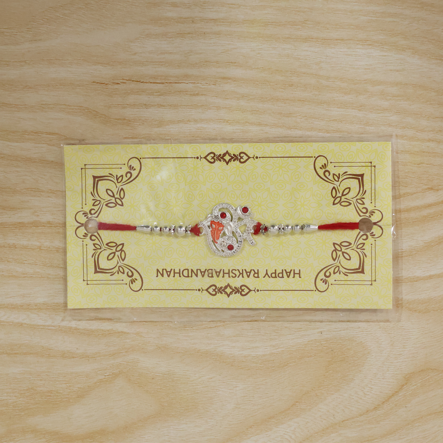 Elegant Silver Ganesh Rakhi bracelet displayed on decorative festive background