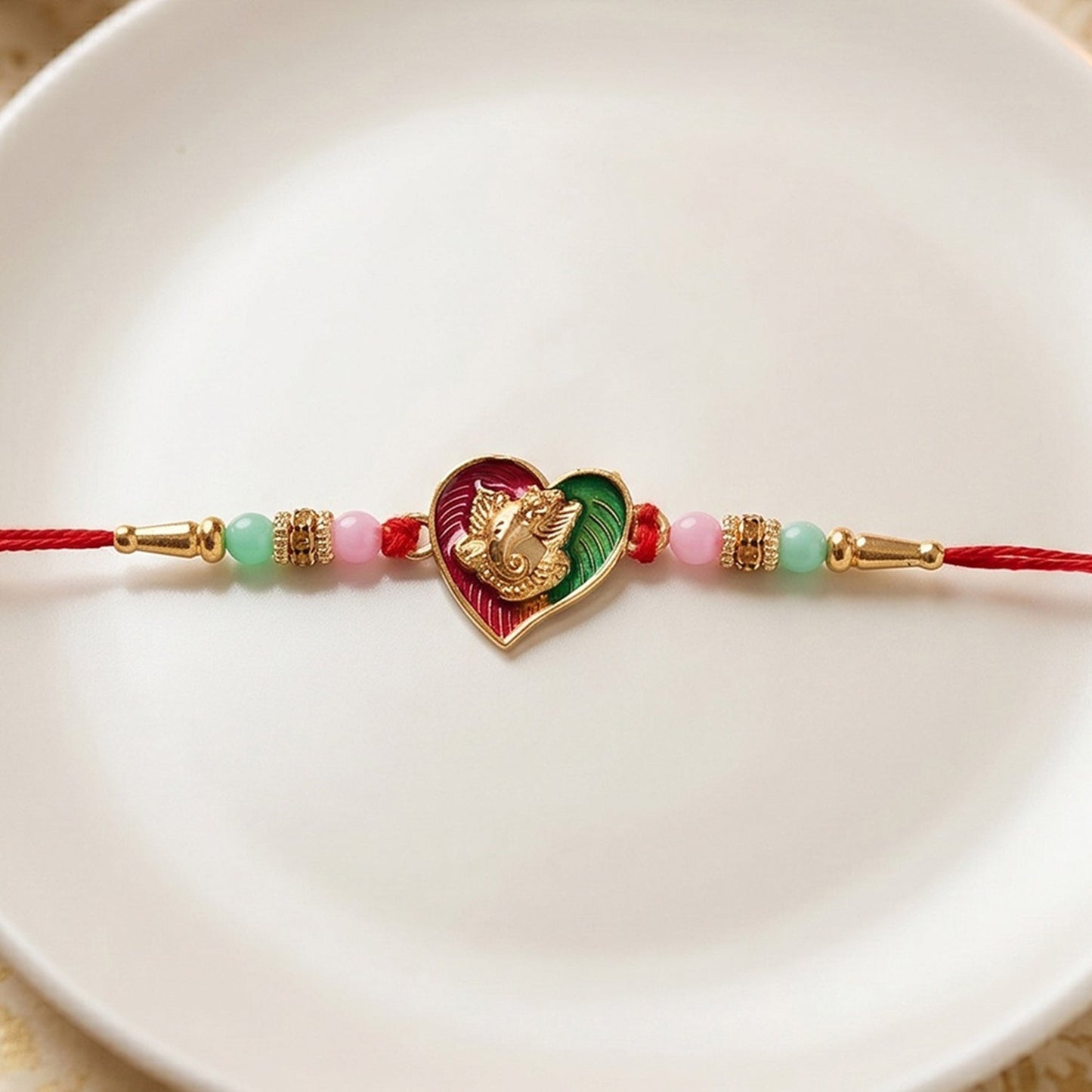 Heart-shaped Lord Ganesha designer Rakhi with decorative beads