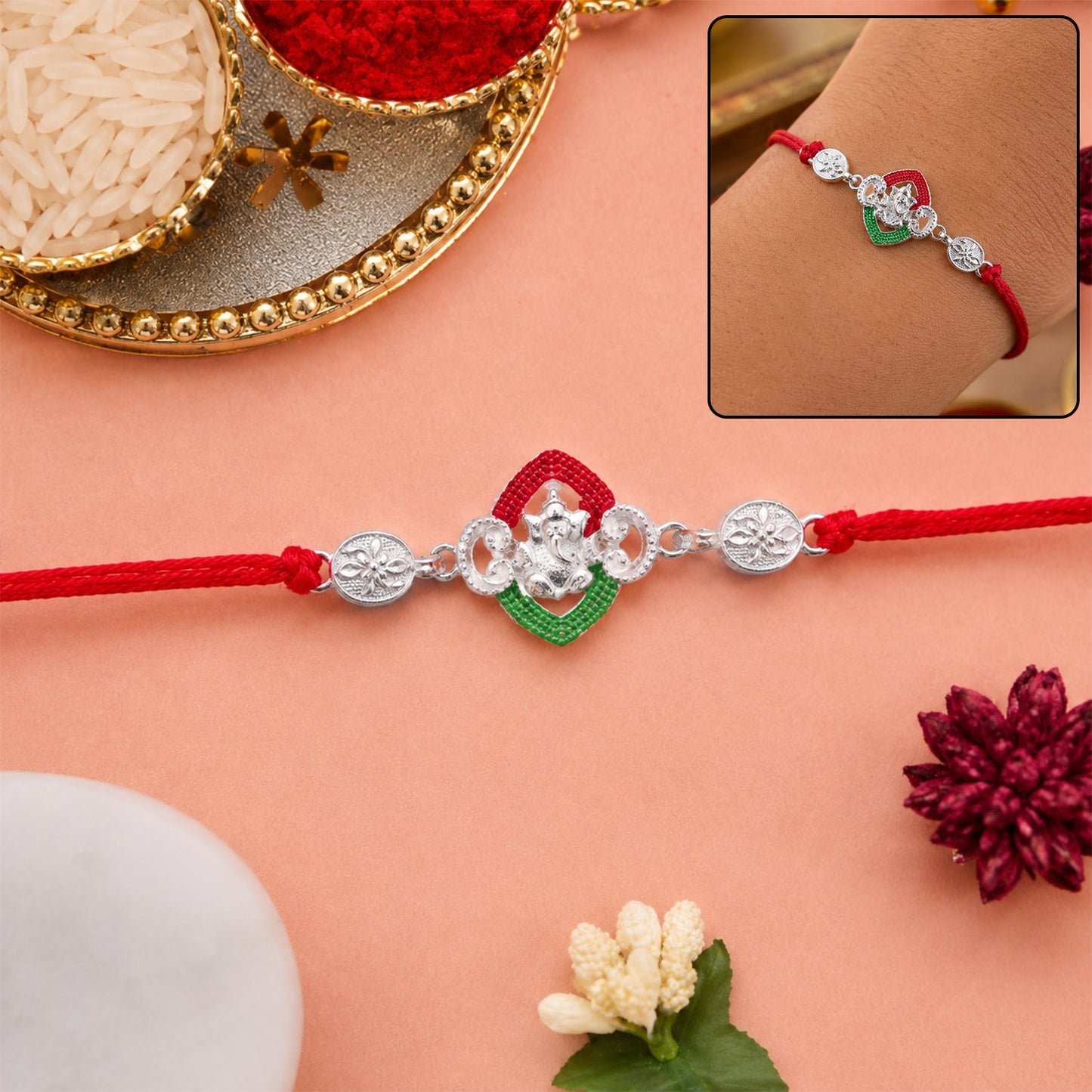 Silver Green Floral Rakhi with red thread on a white background