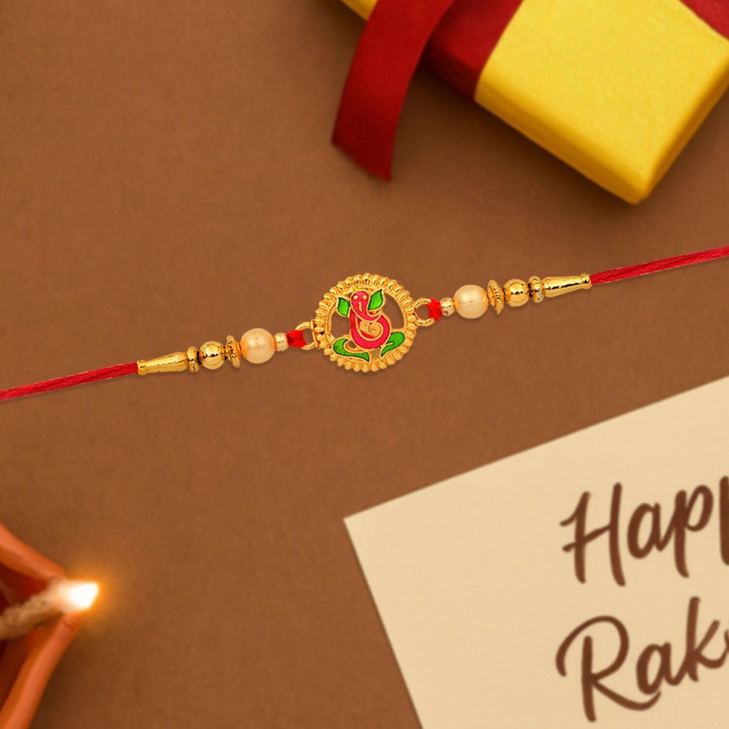 Detailed Ganesha Rakhi showcasing golden beads and intricate enamel detailing