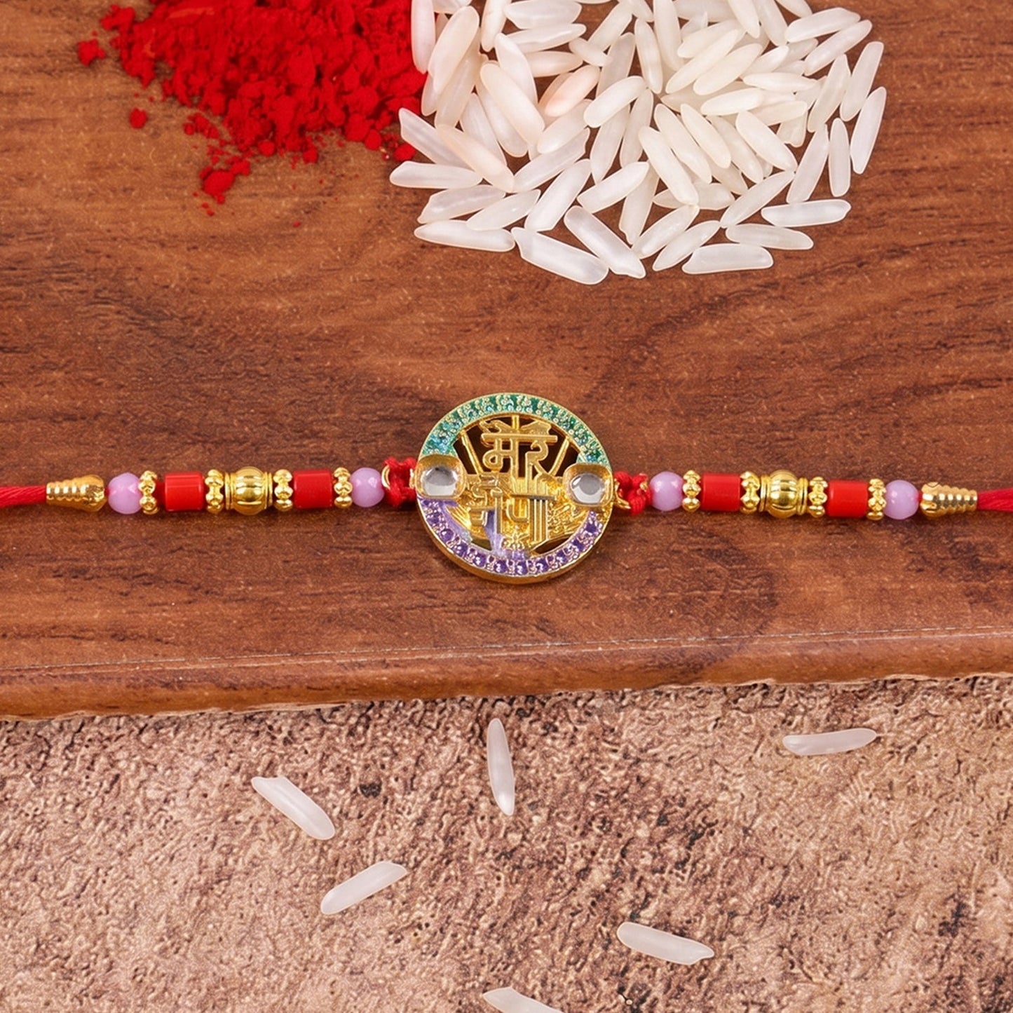 Elegant designer Rakhi with stone centerpiece and vibrant red thread suitable for Raksha Bandhan