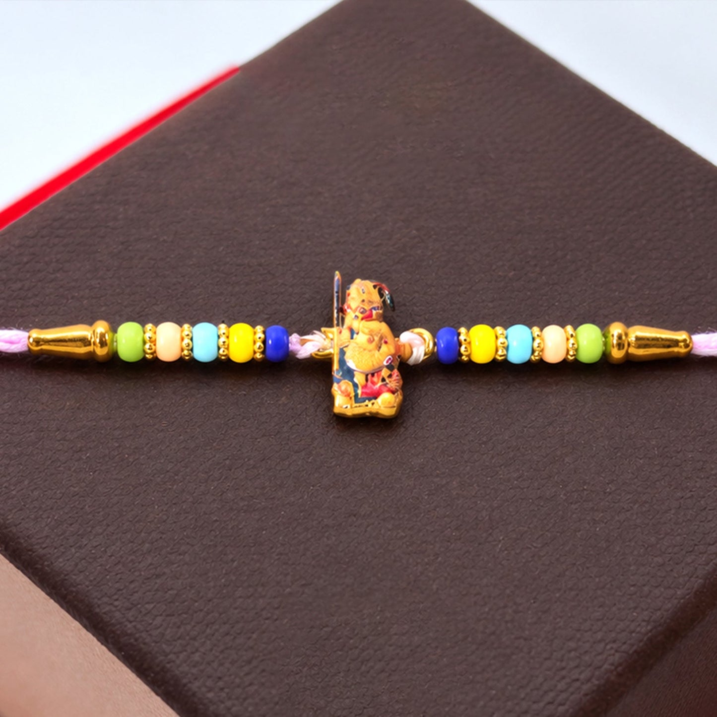 Close-up of Hanuman Ji designer Rakhi with colorful beads