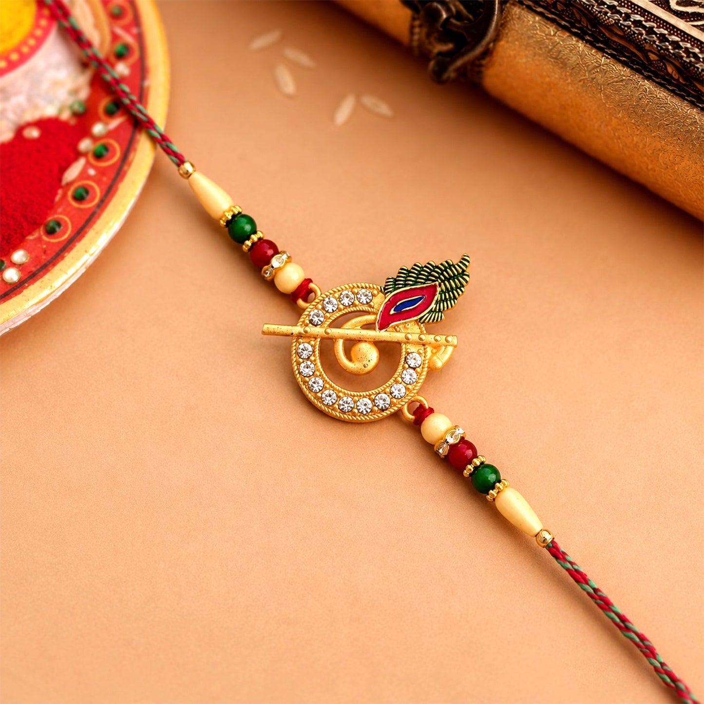 Close-up of a Krishna Flute Rakhi showcasing the intricate stone-studded peacock feather.