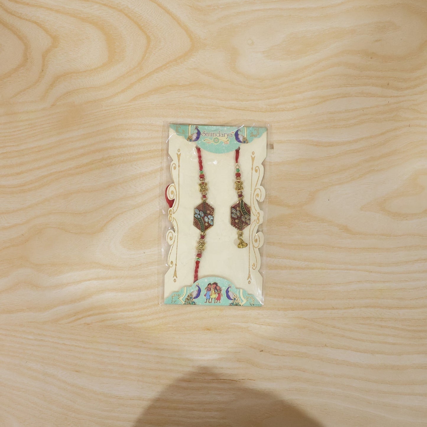 Set of Meenakari Pot Bhabhi Rakhi with threads visible