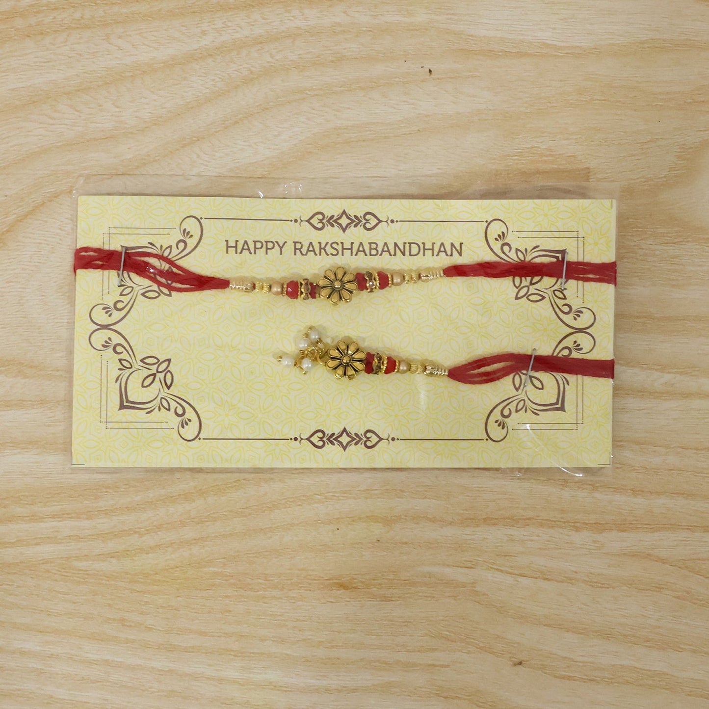 Elegant golden floral Rakhi with pearl bead accents for Bhabhi
