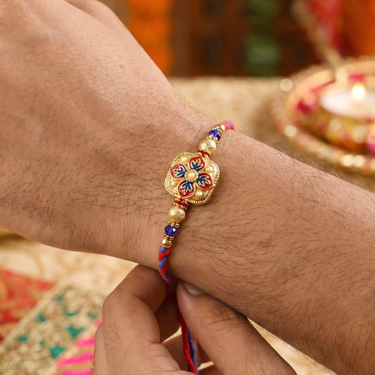 Close-up of peacock latkan on floral meenakari Rakhi