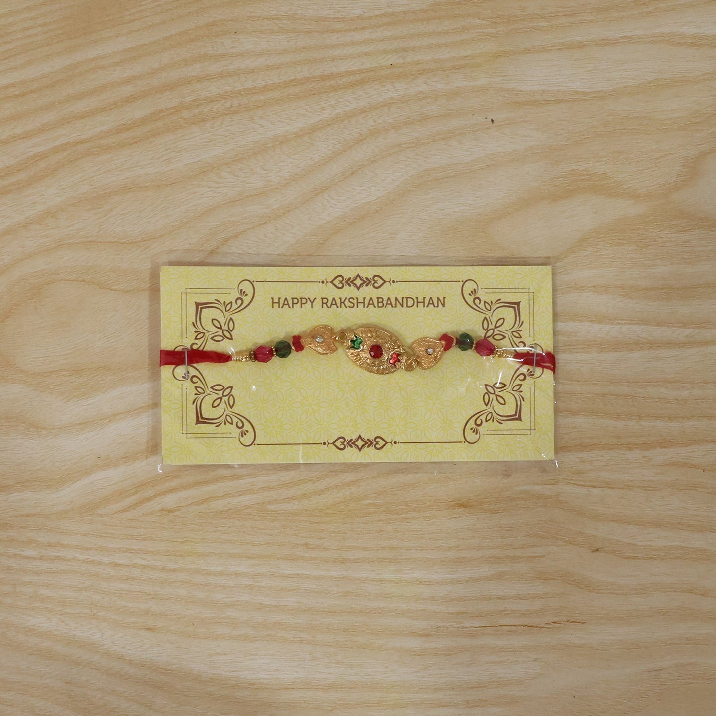 Elegant golden Rakhi with vibrant bead accents