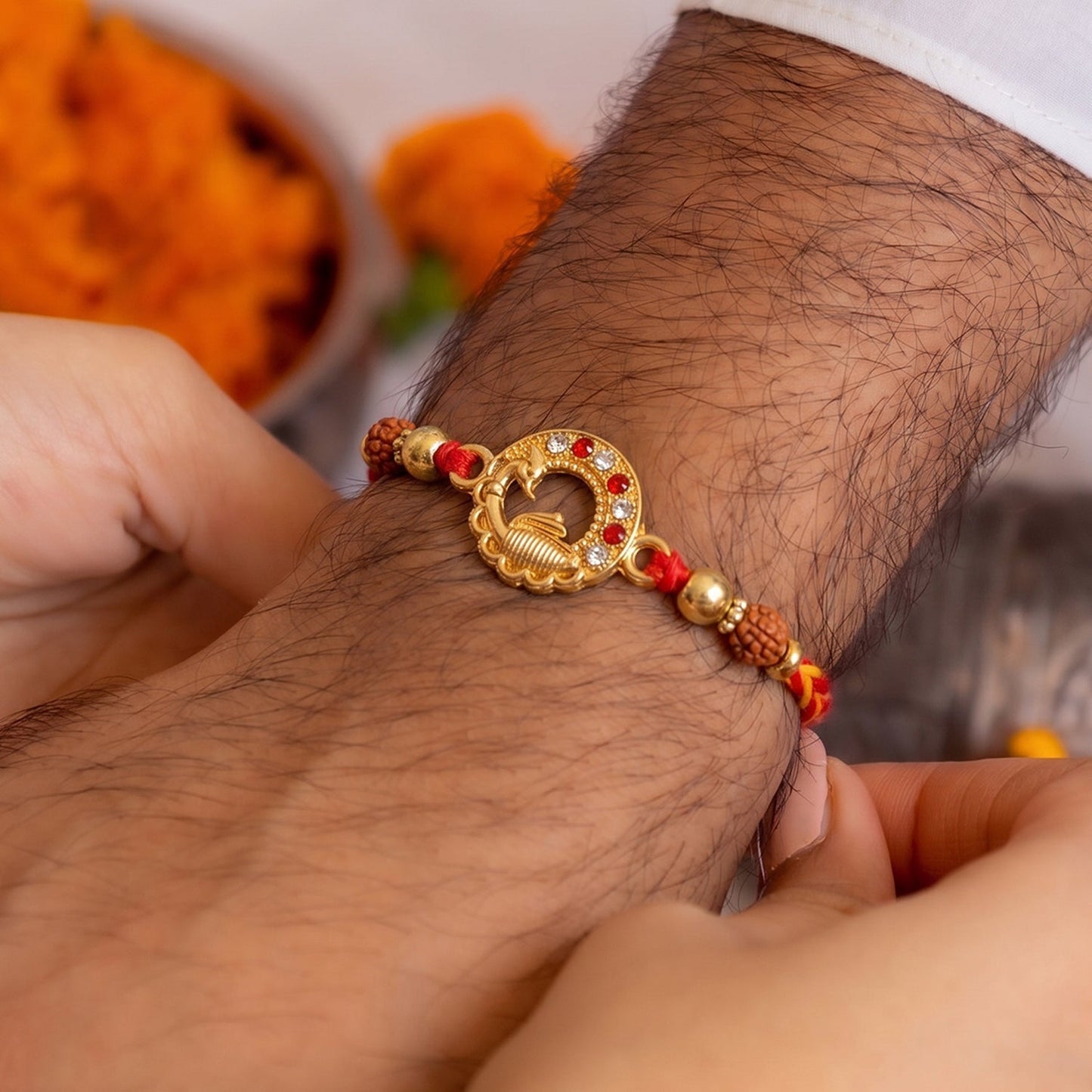 Close-up of golden peacock centerpiece with Rudraksha beads on Rakhi
