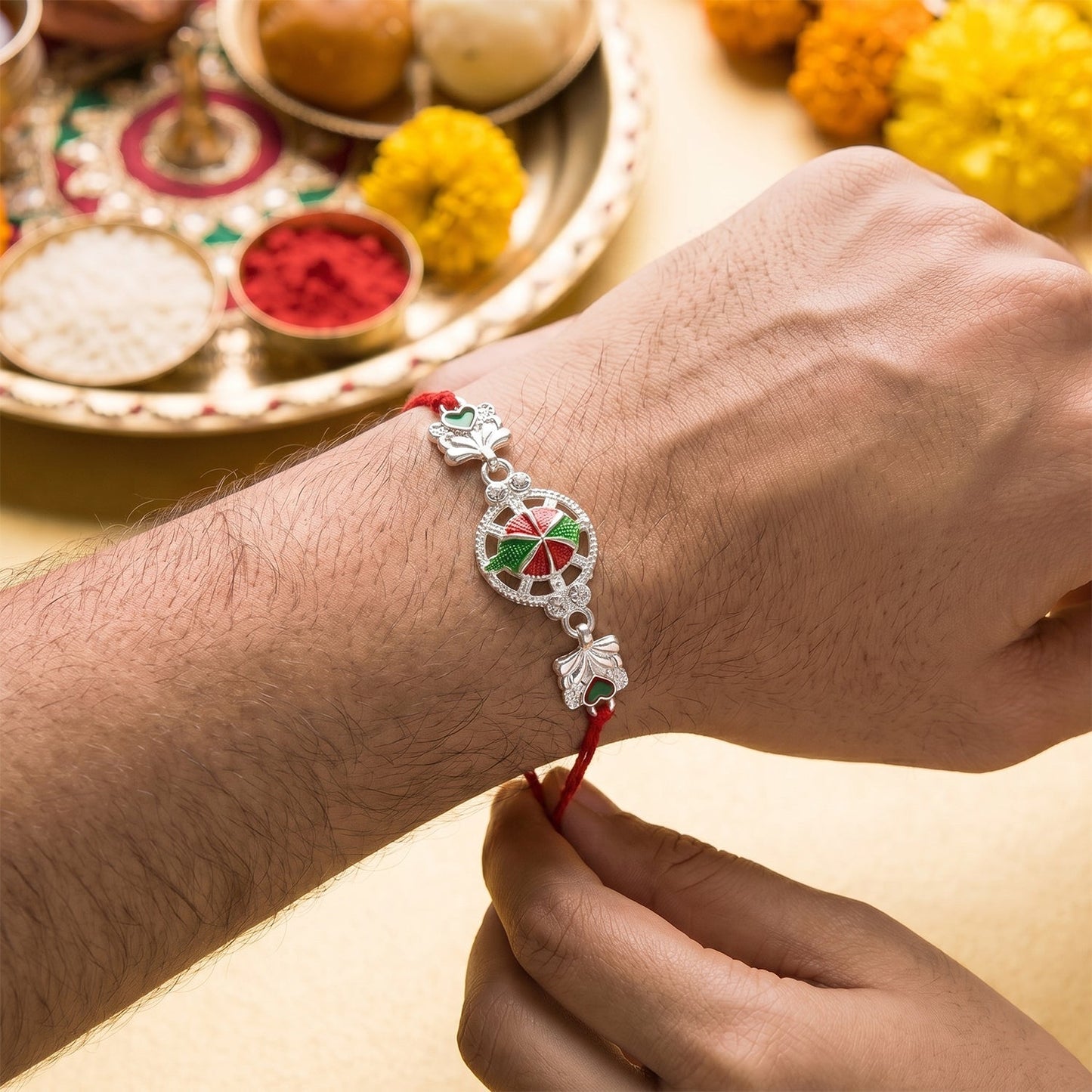Silver floral Rakhi showing red soft thread detail