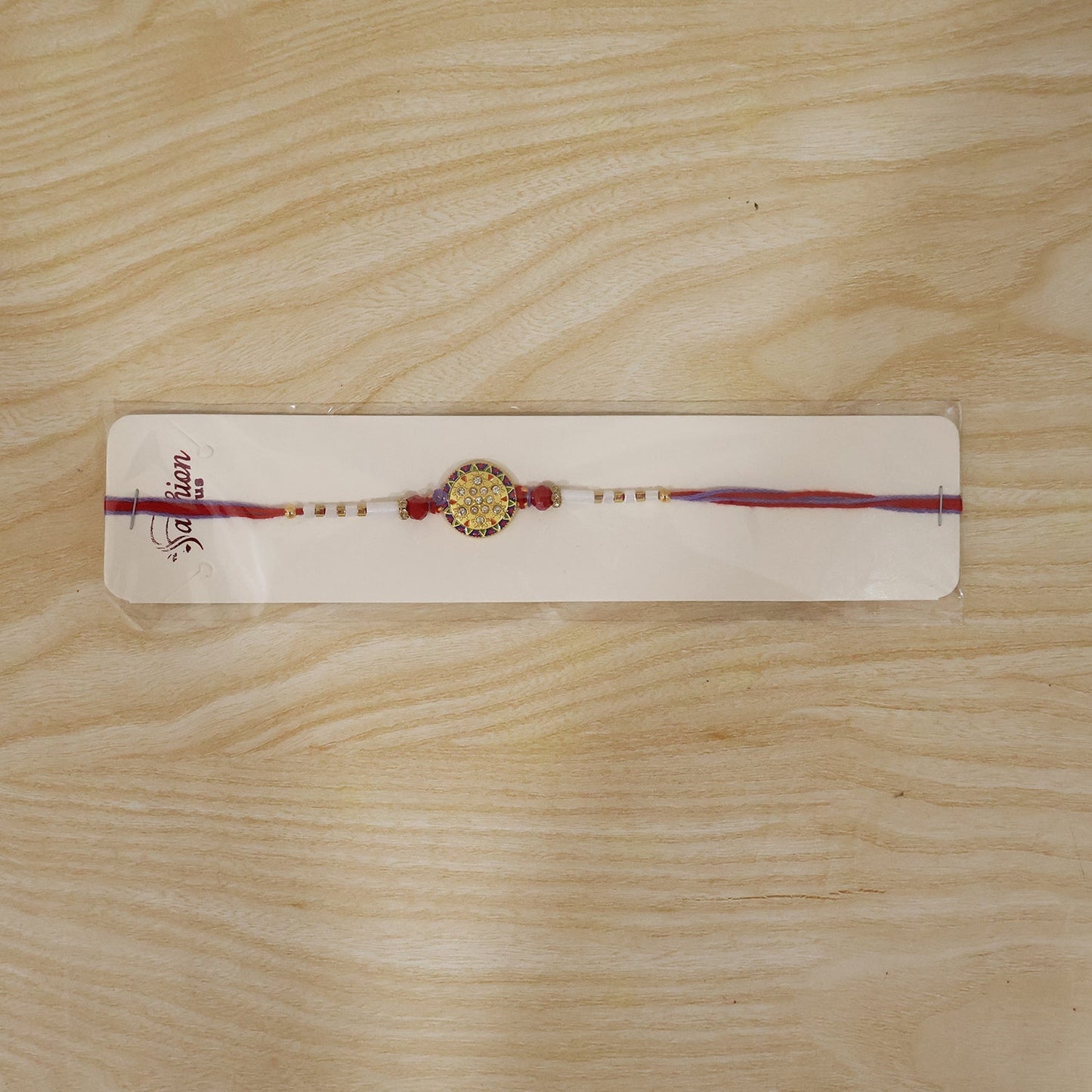 Rakhi packaging featuring white beads and round stone design