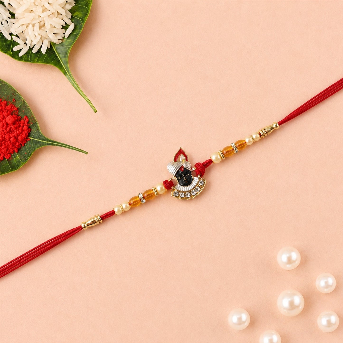 Rakhi tied in red thread showcasing pearl bead design