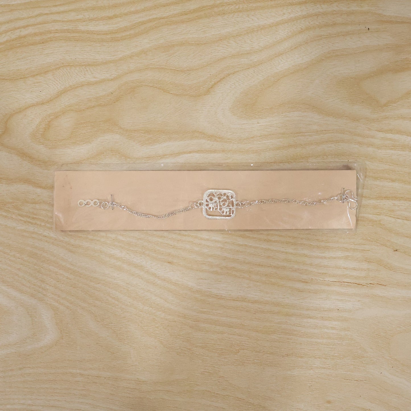 Silver Radhe Radhe Rakhi in elegant packaging, perfect for gifting.