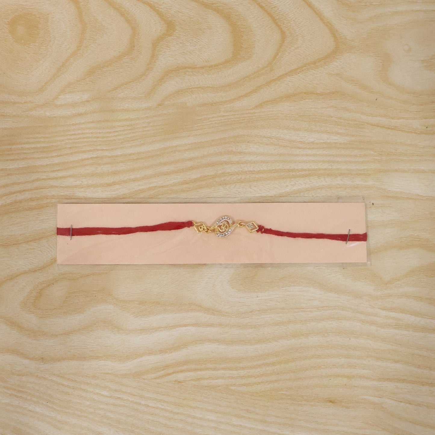 Golden Om Rakhi with stone work on white background